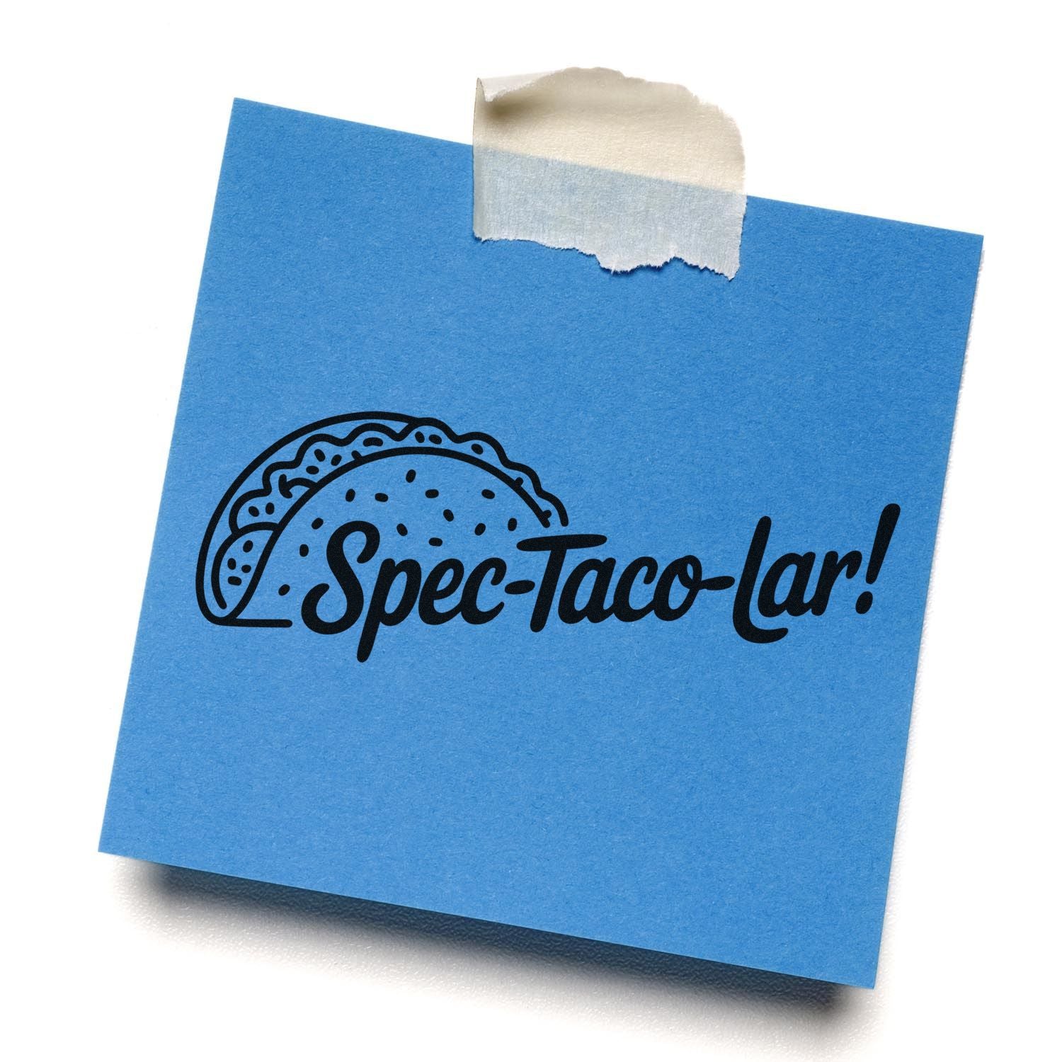 Blue sticky note with black taco stamp reading Spec-Taco-lar! secured with beige masking tape.