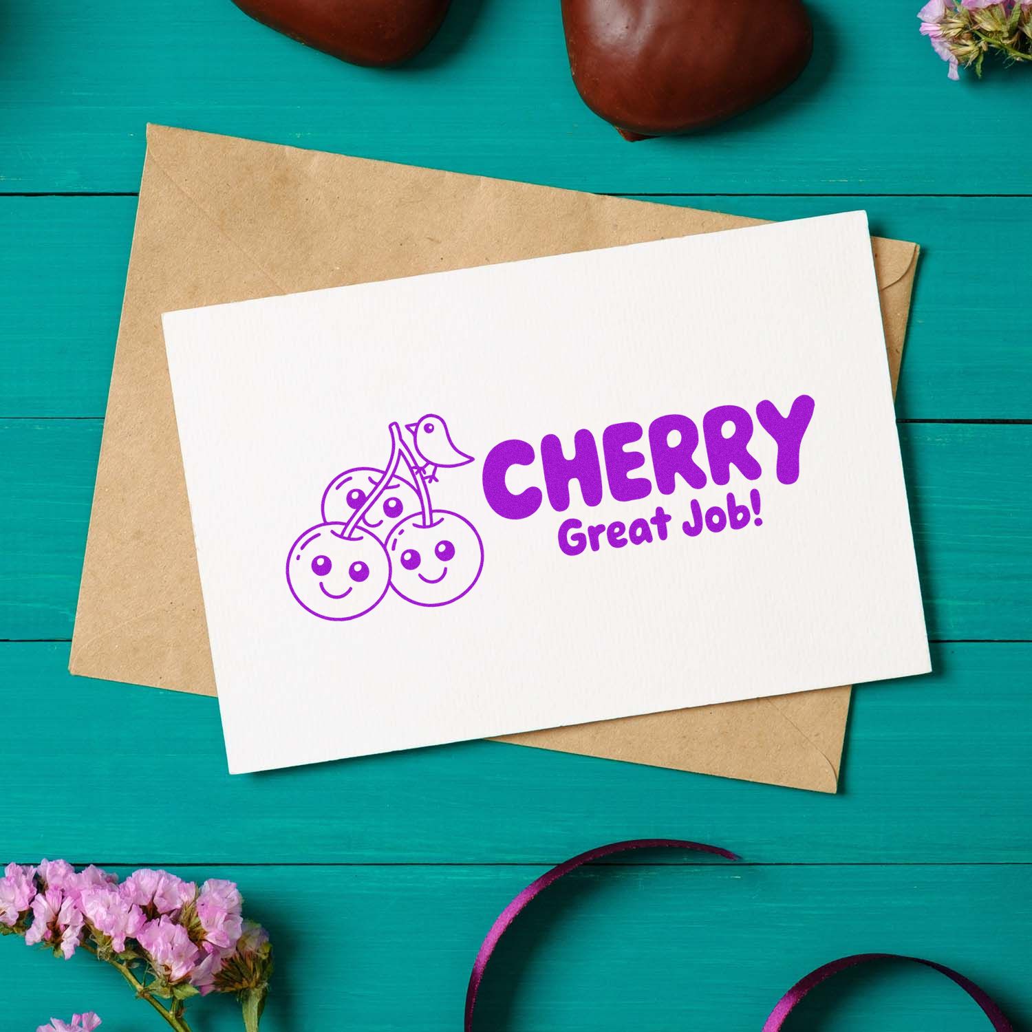 Purple cherry Great Job! stamp and seal on a white card over a kraft envelope, set on a teal wood background.