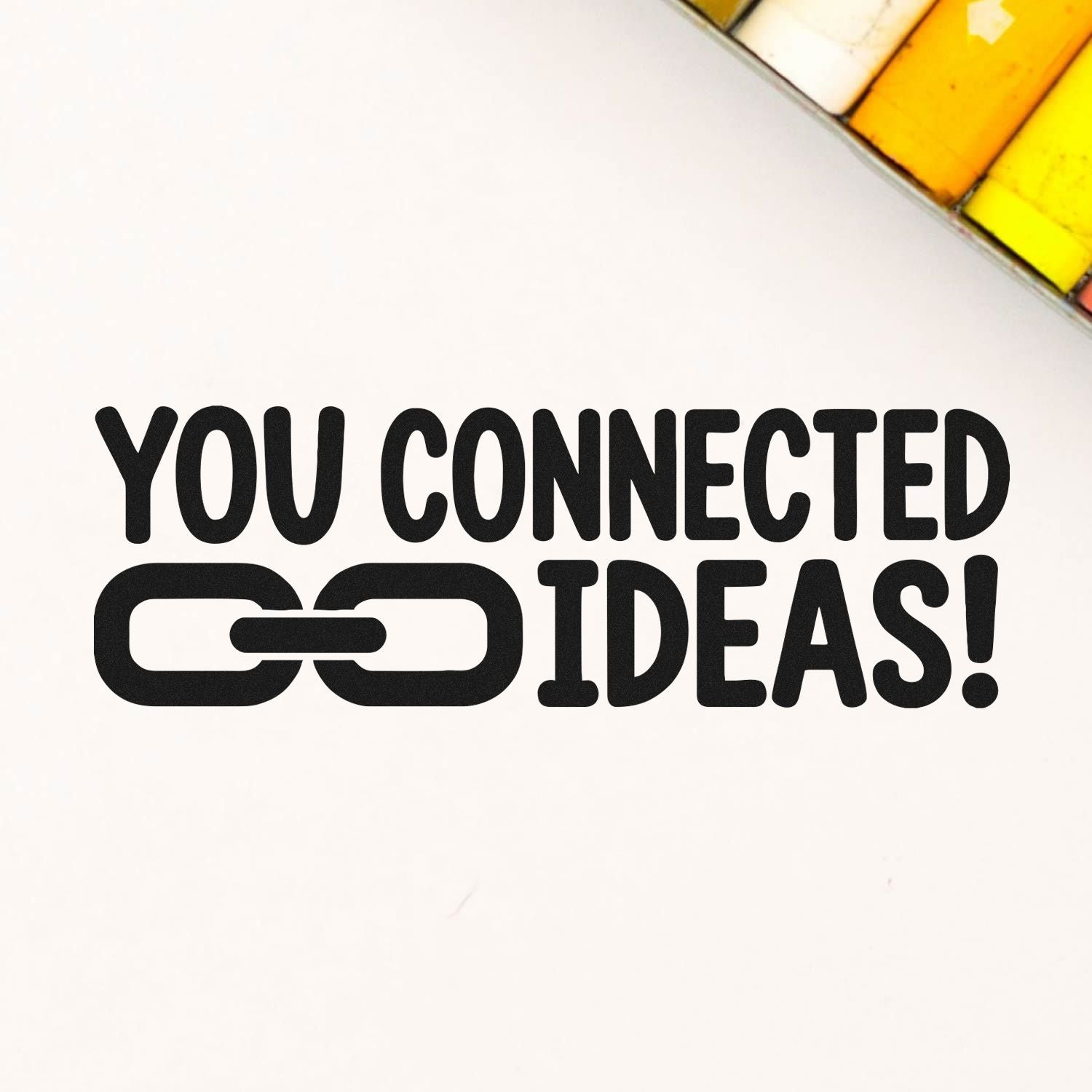Black You Connected Ideas! stamp with chain link icon on white, beside yellow and orange stamp and seal products.