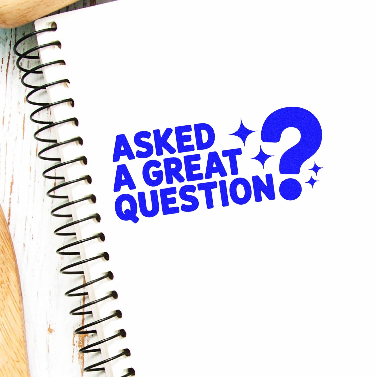 Blue Asked a Great Question stamp with a question mark on a white notebook page, spiral binding at left.