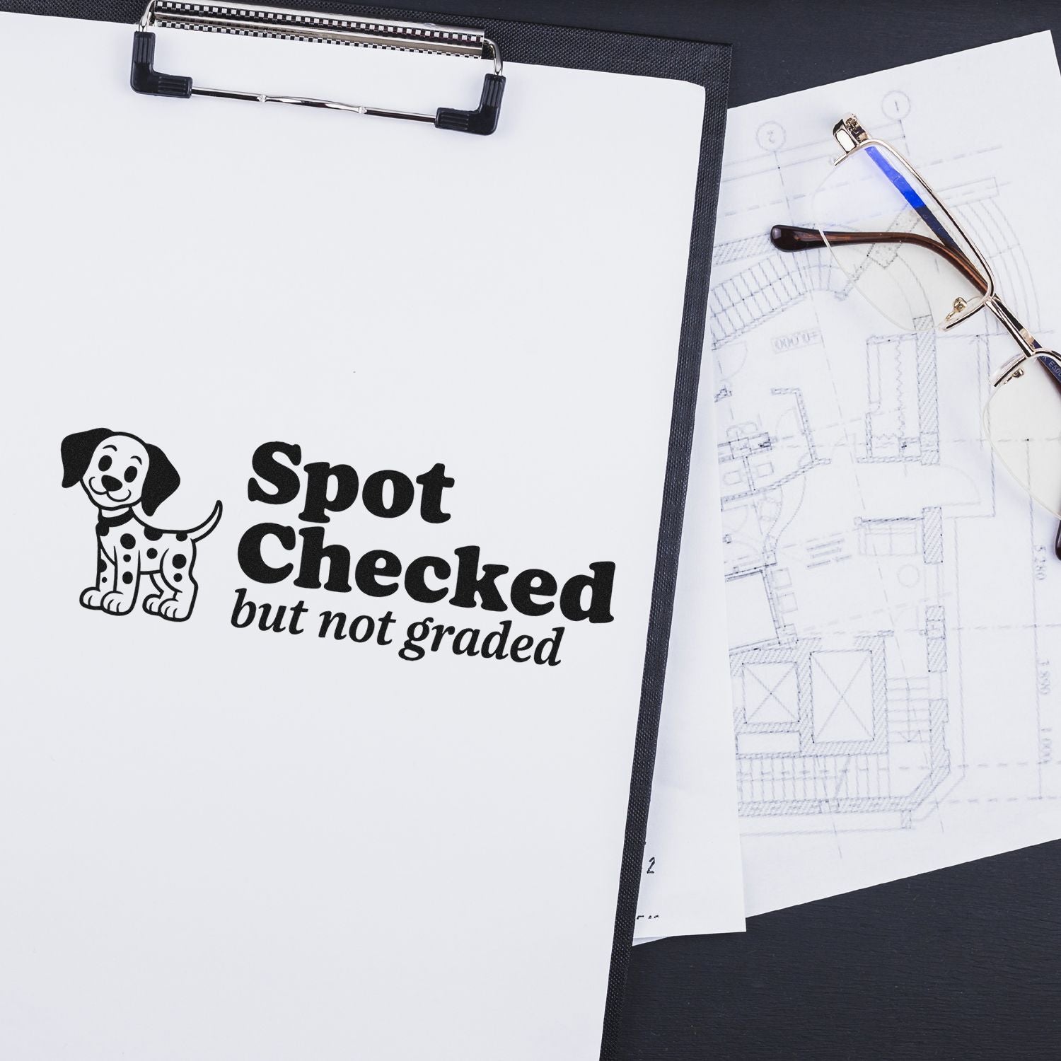 Black stamp/seal with dog logo and Spot Checked but not graded on white clipboard, beside blueprints and glasses.