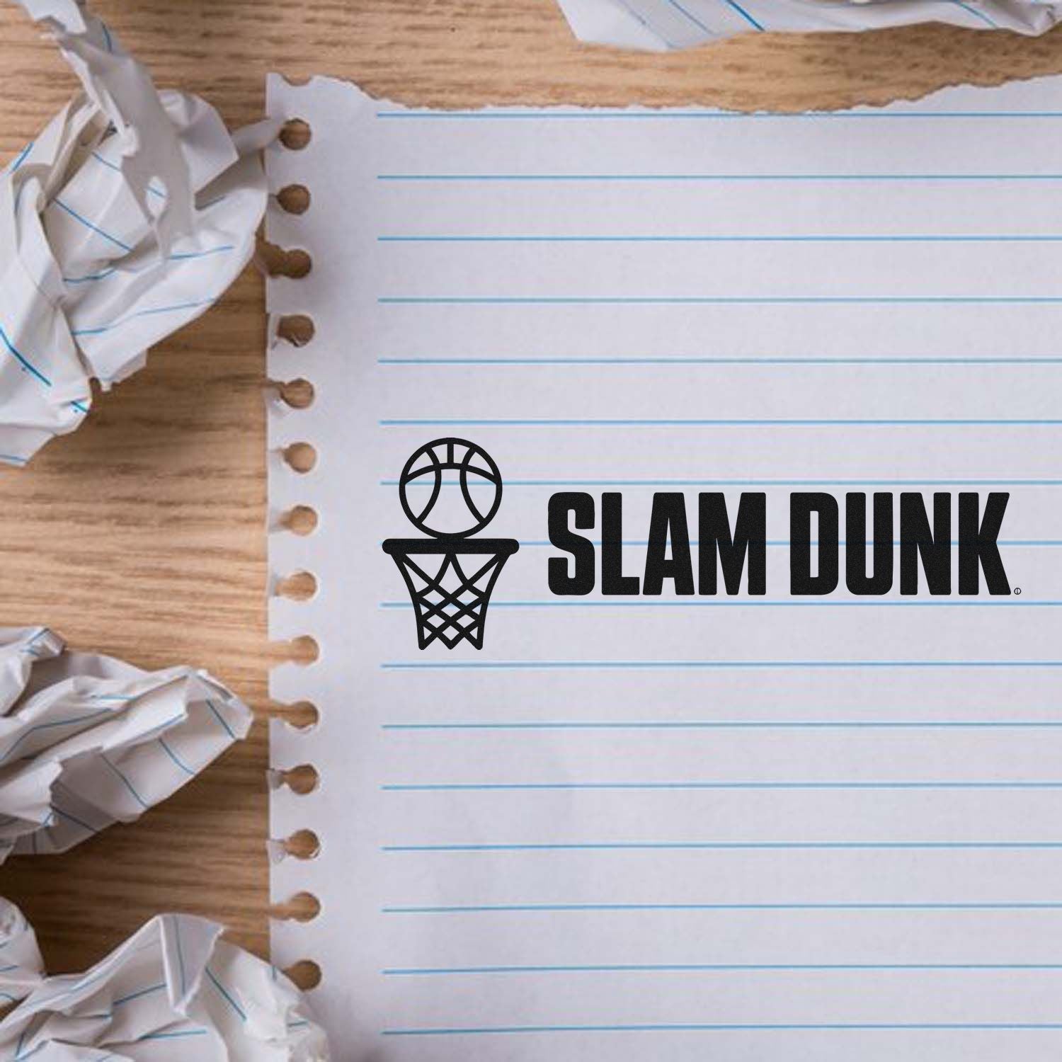 Black Slam Dunk basketball stamp/seal on torn lined notebook paper, with crumpled scraps and wood background.