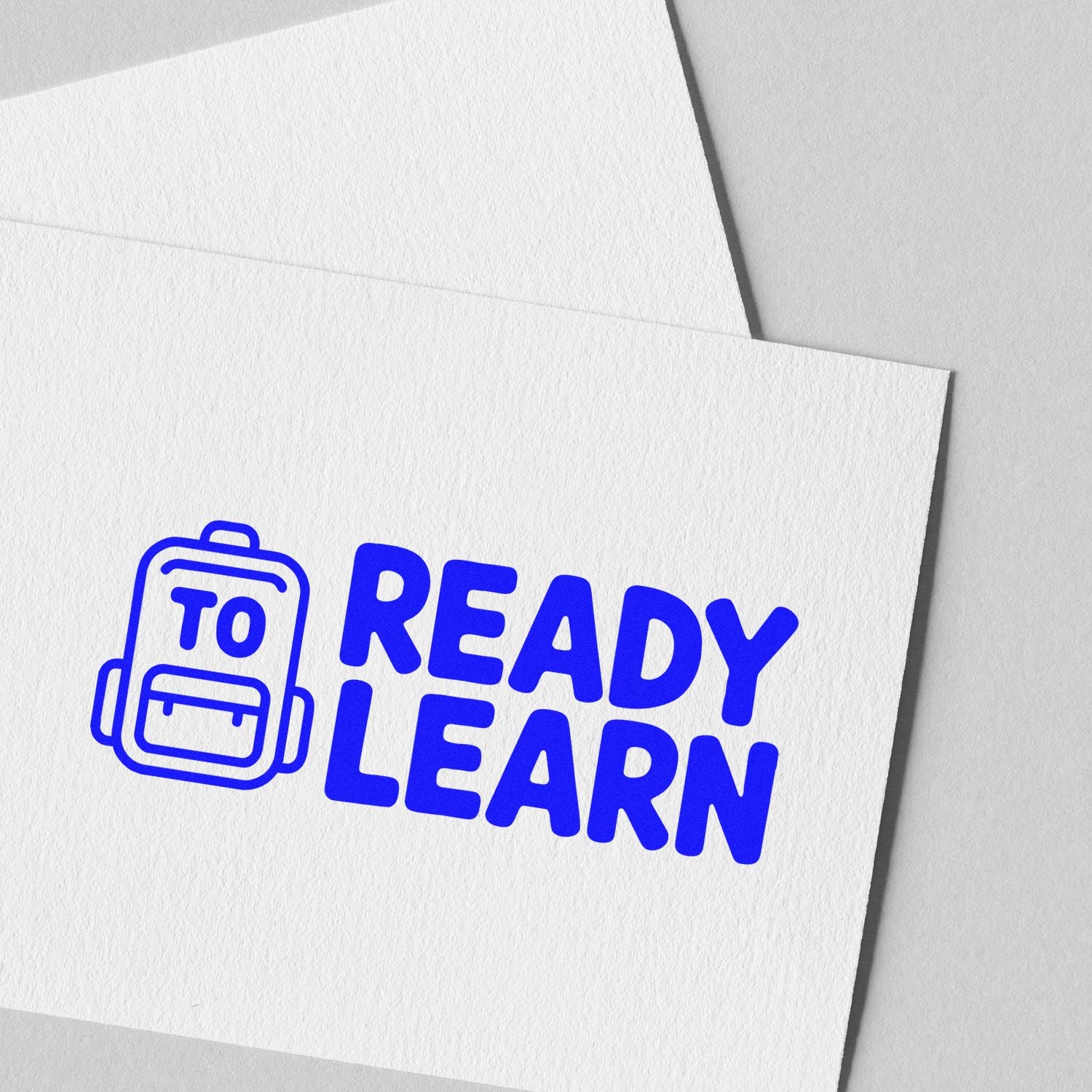 Blue READY LEARN backpack stamp on white textured envelopes, ideal for stamp and seal products.