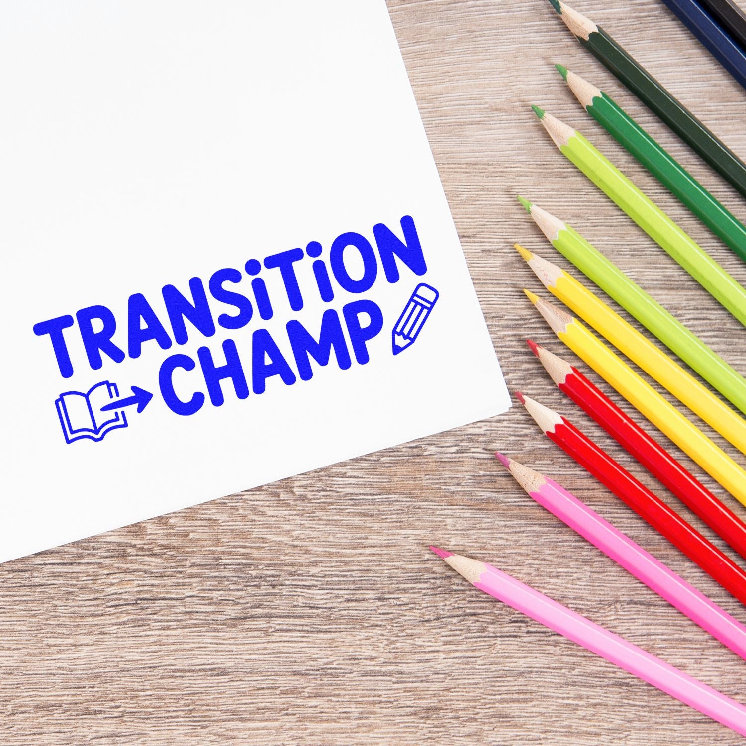 Blue Transition Champ stamp and seal design on white paper beside colorful pencils on a wood desk.