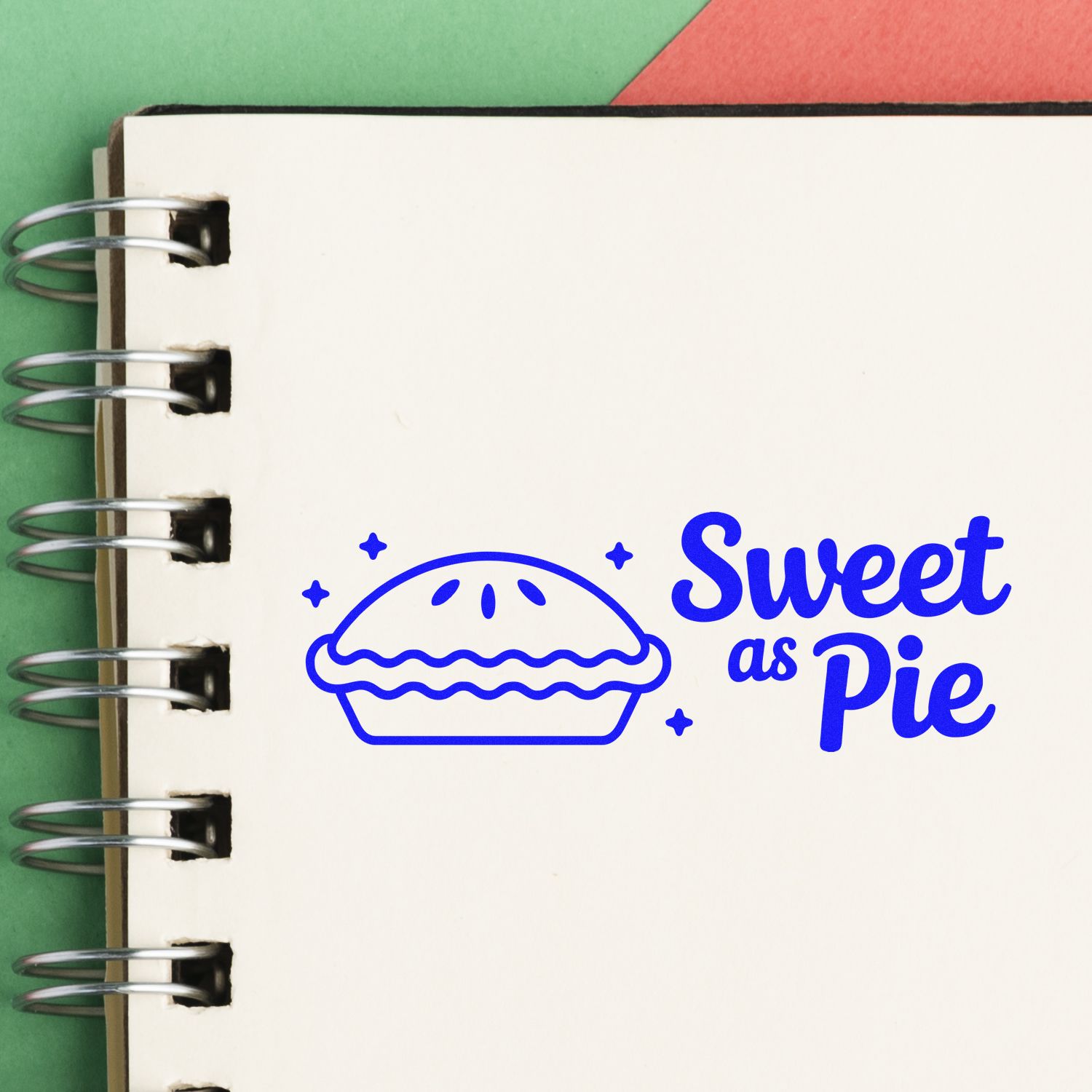 Blue Sweet as Pie pie stamp seal on a white spiral notebook page, with green and red background accents.