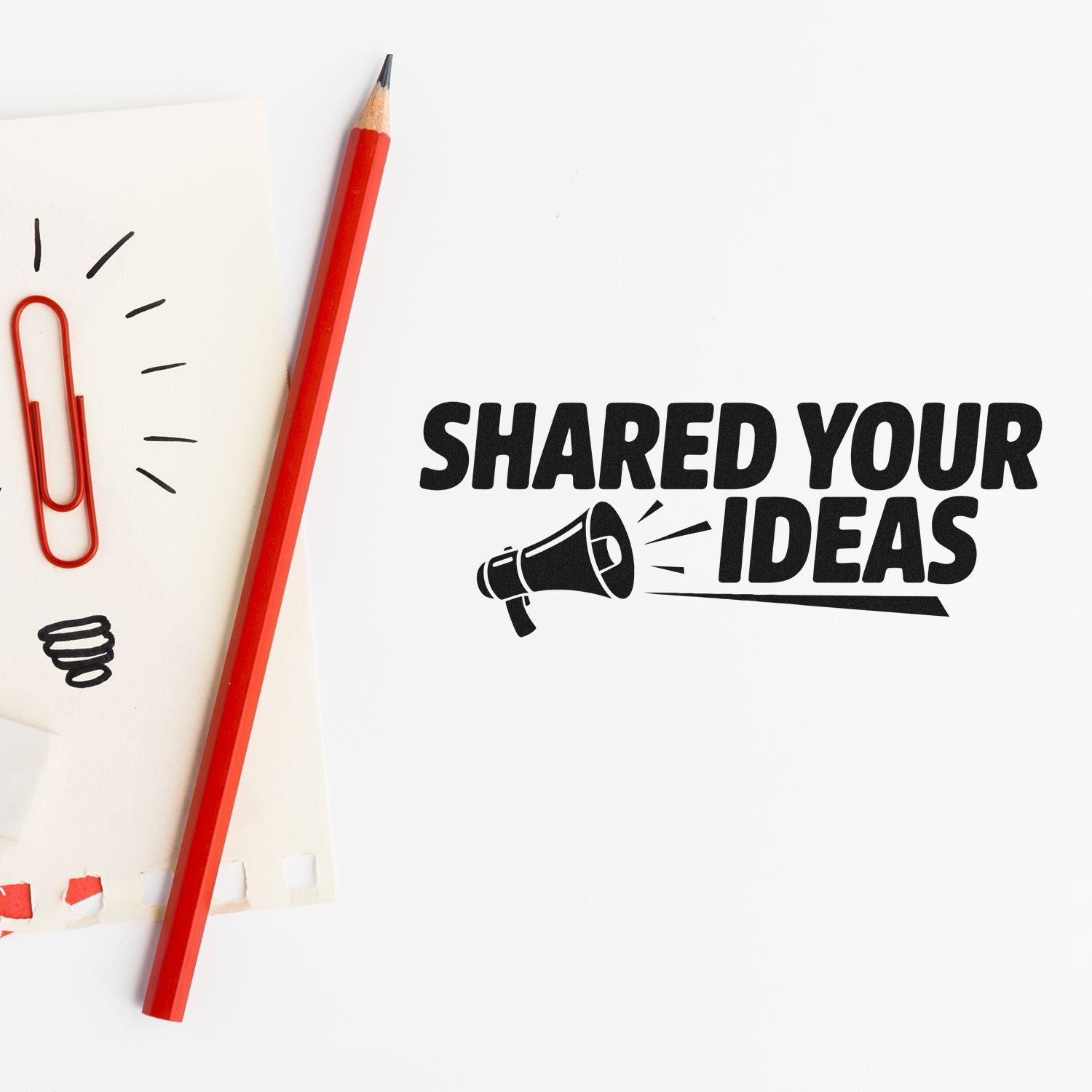 Red pencil and paperclip beside a black stamp-style seal reading SHARED YOUR IDEAS on white paper.