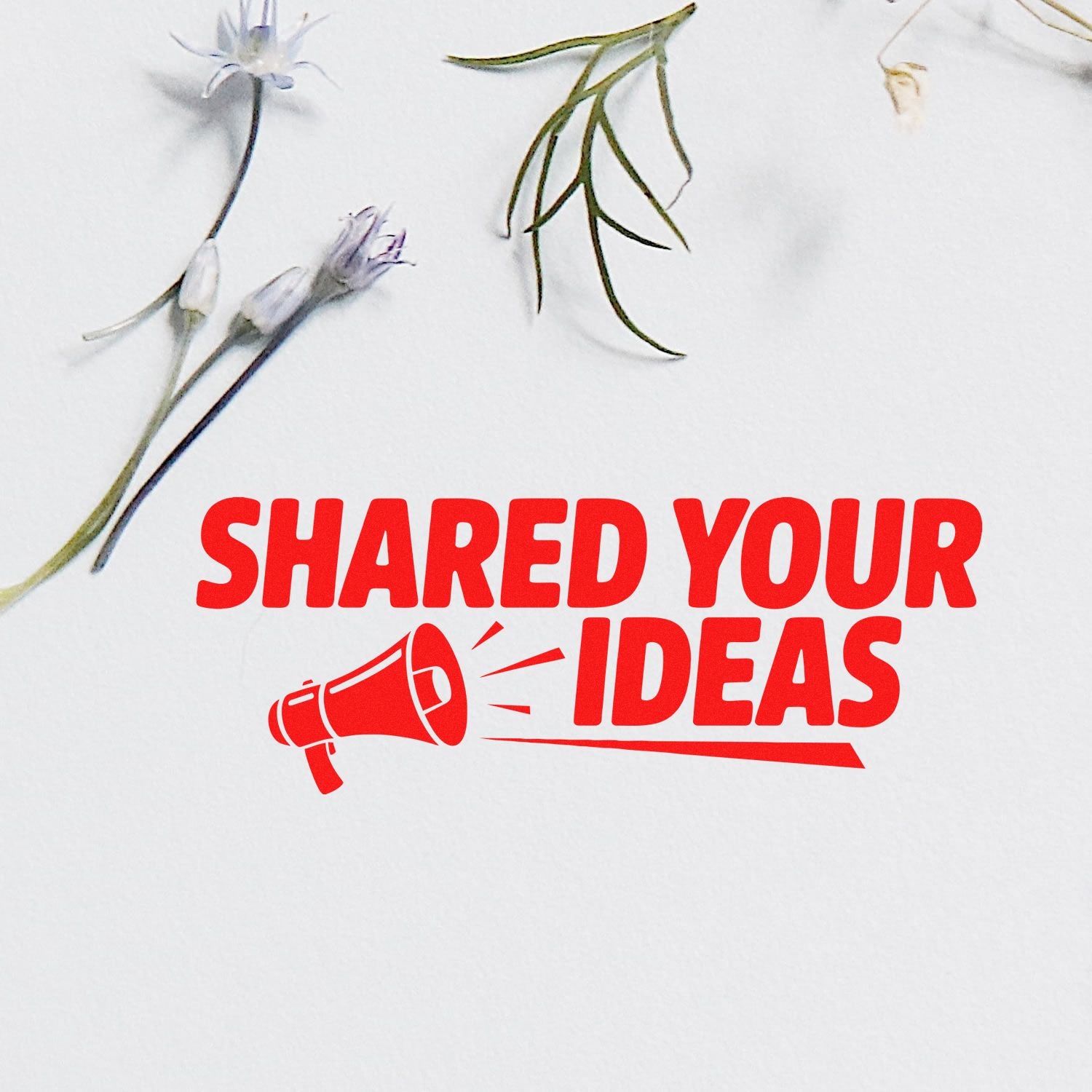 Red custom stamp seal reading SHARED YOUR IDEAS with megaphone on white paper, accented by floral stems.