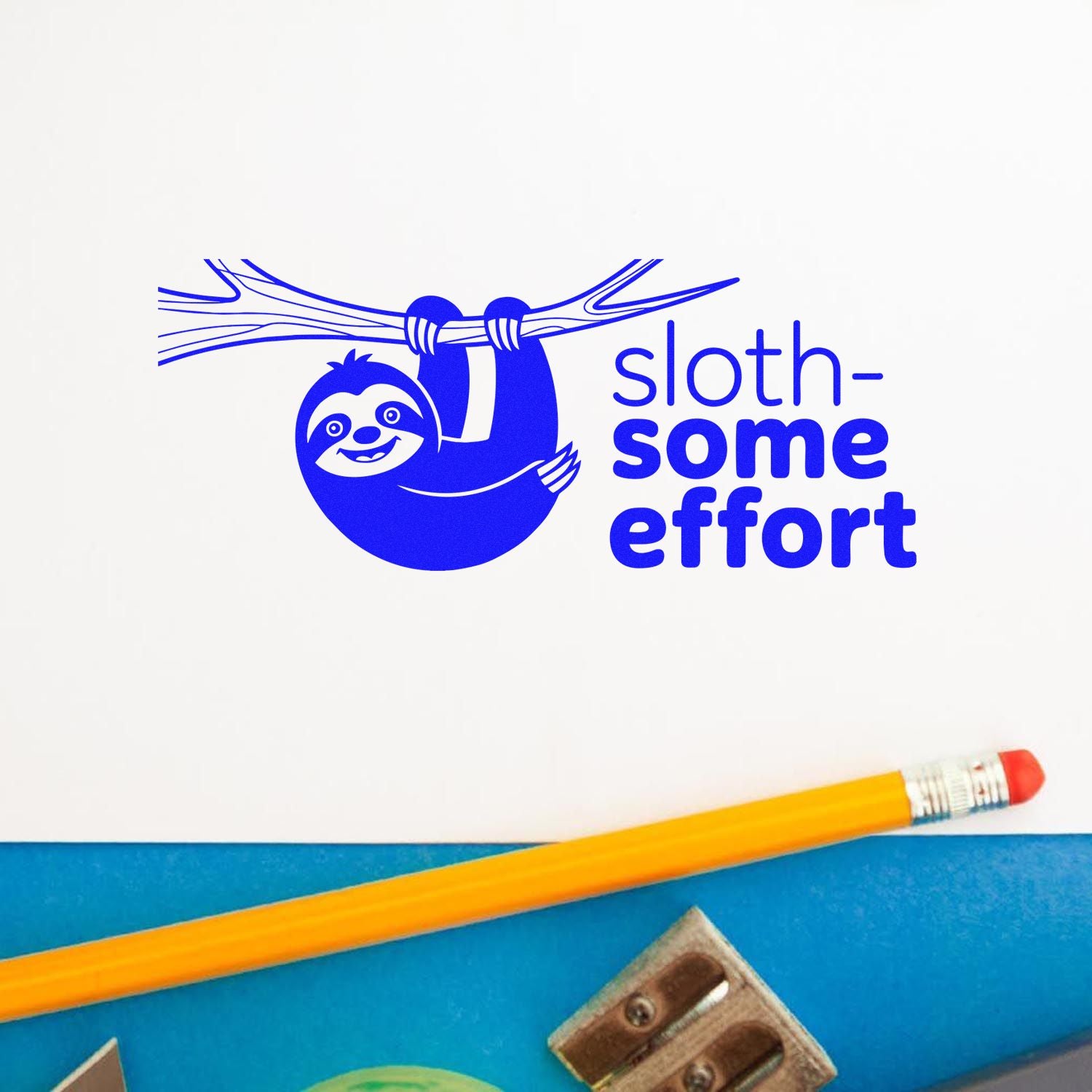 Blue sloth-themed stamp and seal with sloth-some effort text on white paper, beside a yellow pencil and blue stationery.