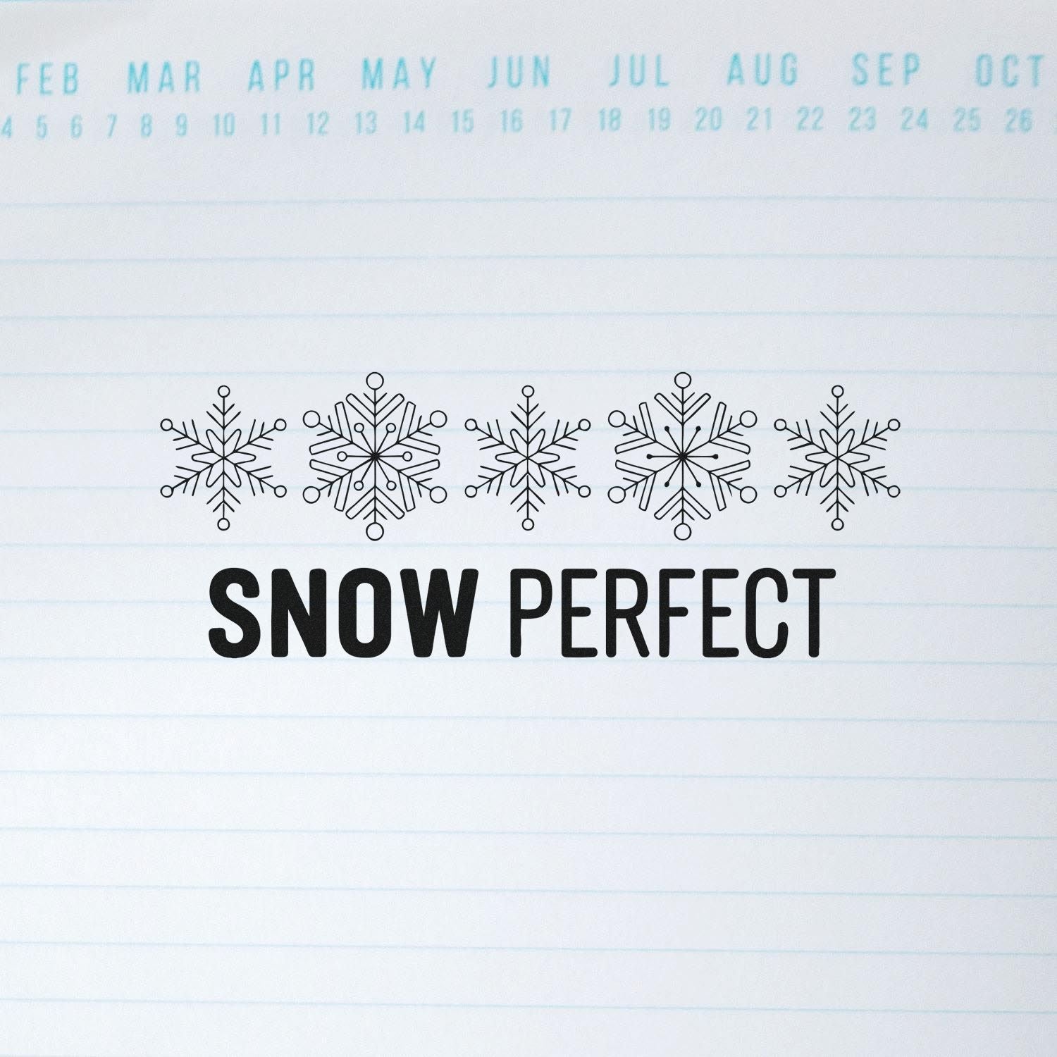 Black snowflake stamp and seal reading SNOW PERFECT on white lined paper with light blue calendar dates.