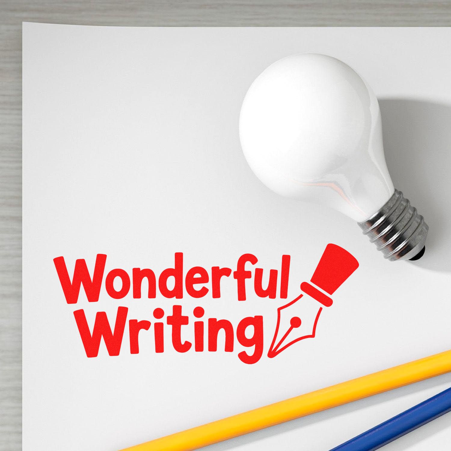 Red Wonderful Writing stamp and seal with pen nib icon on white paper, beside a white bulb-shaped seal and yellow-blue pencils.