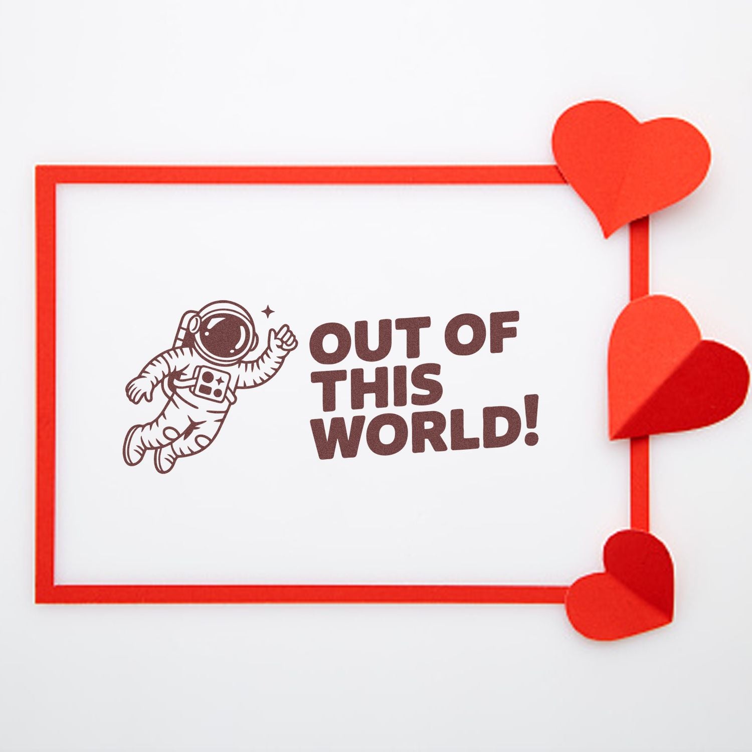 Red stamp seal with astronaut and Out of This World! text, bordered in red and accented with paper hearts.