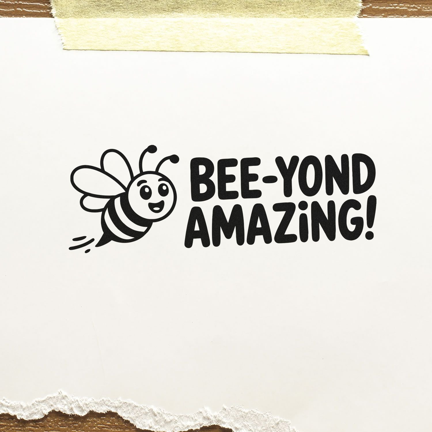 Black bee stamp seal reading BEE-YOND AMAZING! on white paper with masking tape and torn edges.