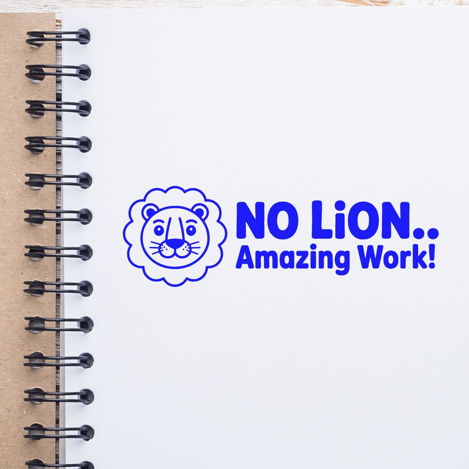 Blue lion rubber stamp seal with "No LiON.. Amazing Work!" on a white spiral notebook page.