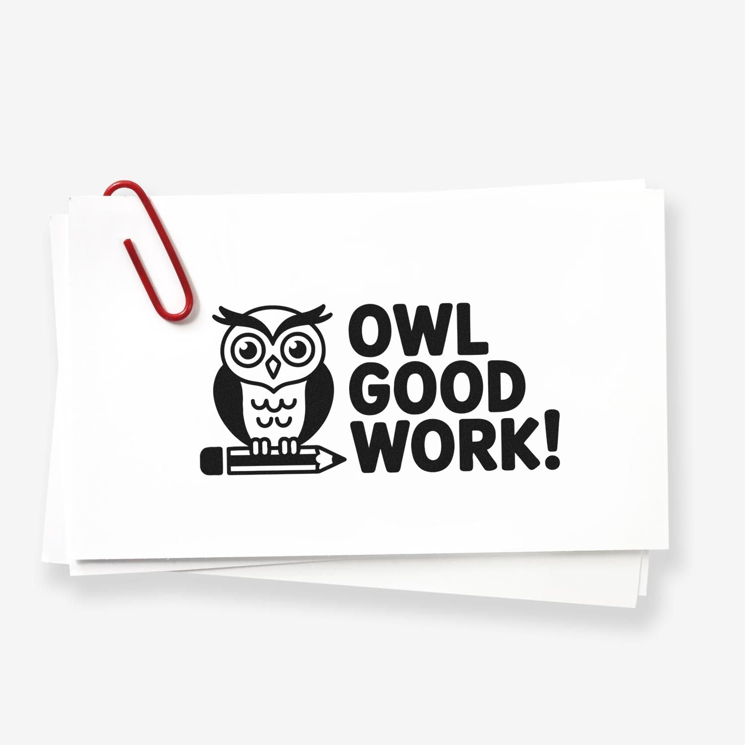 Black stamp and seal design with owl, pencil and OWL GOOD WORK! on white paper, clipped with red paperclip.