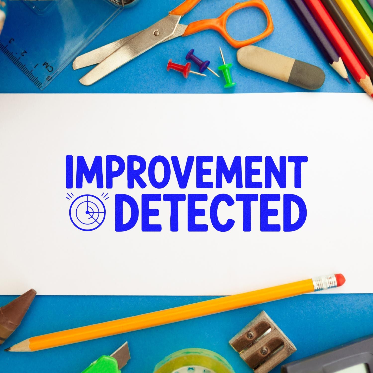 Blue stamp seal reading IMPROVEMENT DETECTED on white paper, surrounded by school supplies and tools.