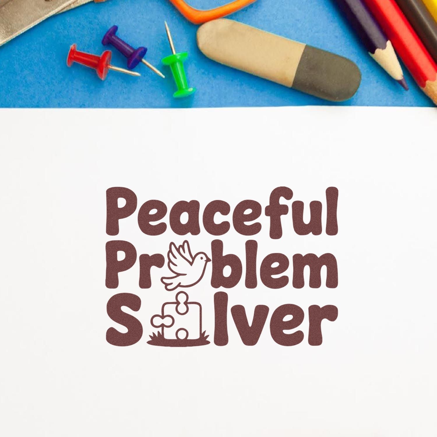 Brown Peaceful Problem Solver rubber stamp and seal with dove and puzzle-piece icon, on white, beside colorful pins and eraser on blue.