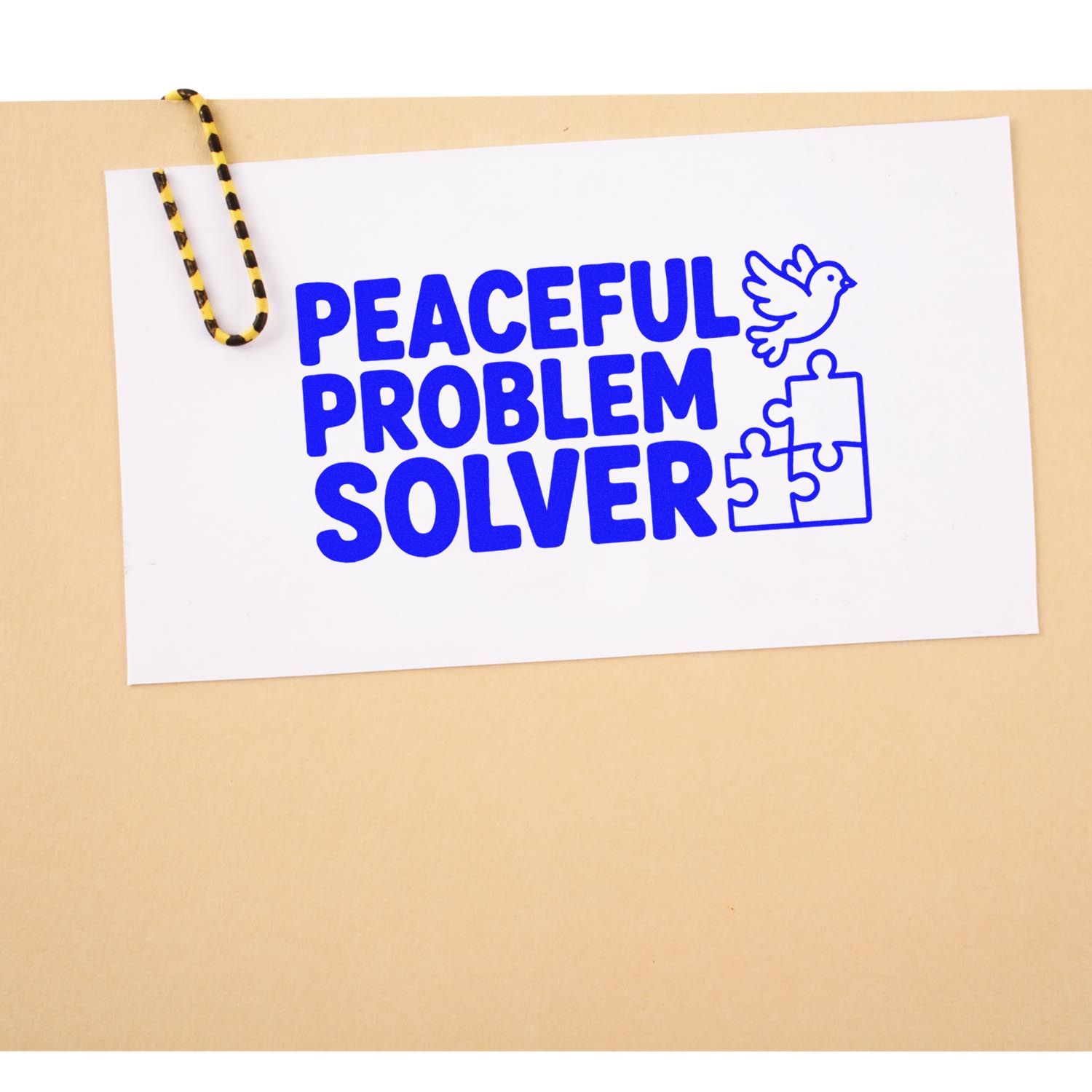 Blue Peaceful Problem Solver stamp seal with dove and puzzle pieces on a white card, clipped to a beige background.
