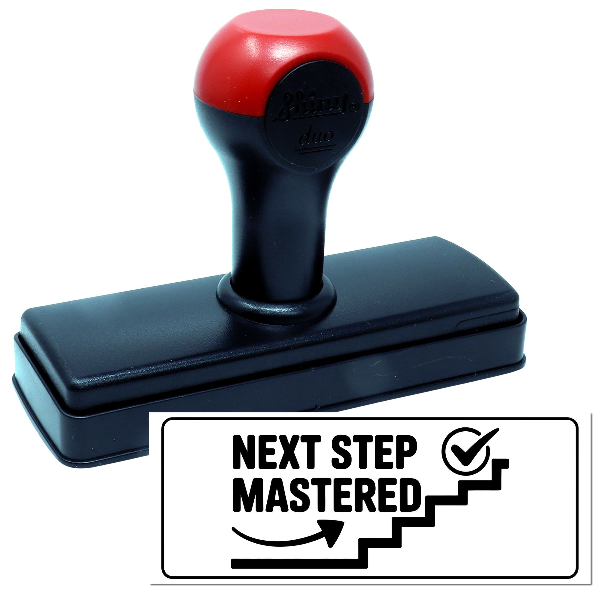 Red and black self-inking stamp and seal with Next Step Mastered impression on a white background.