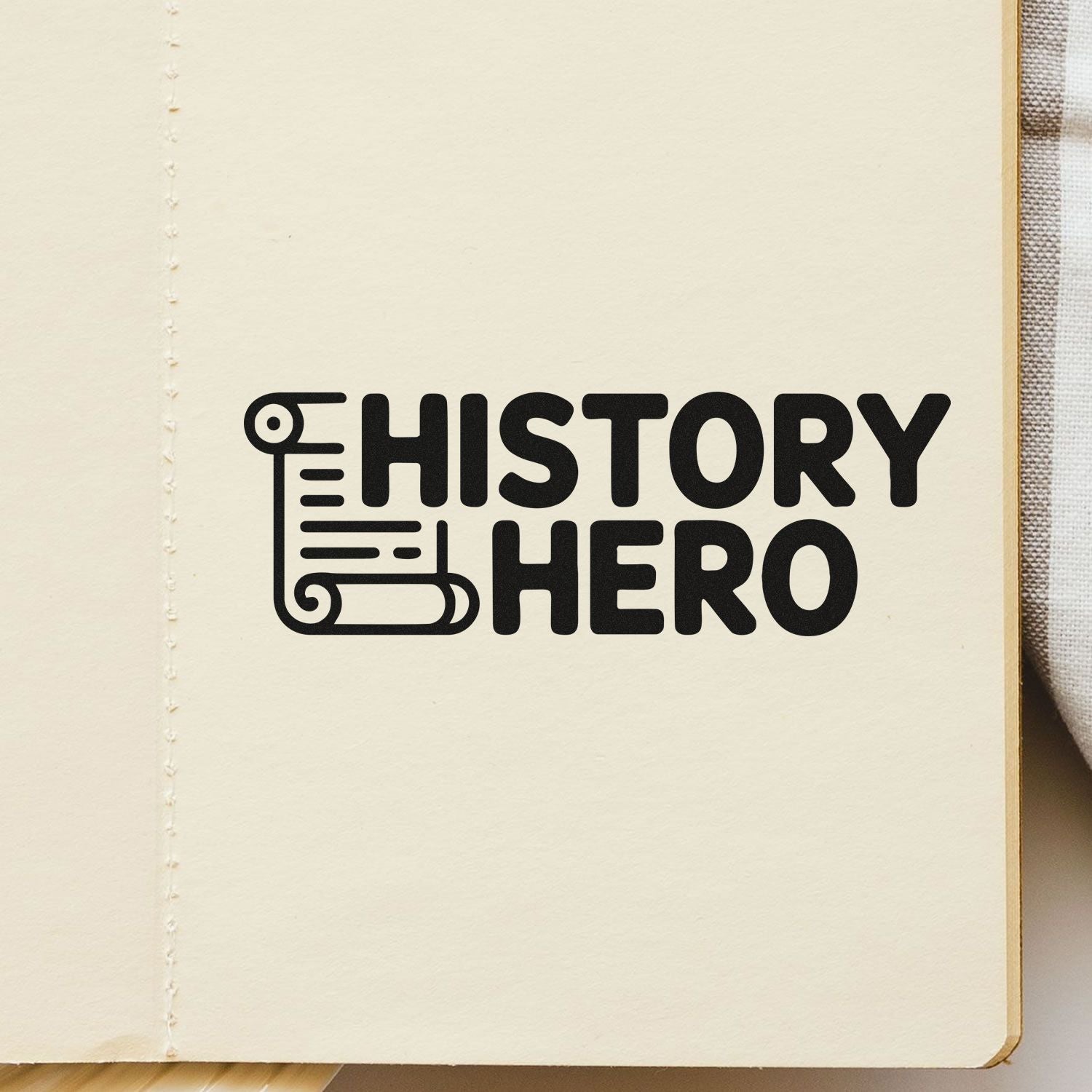 Black HISTORY HERO stamp and seal design with scroll icon on cream notebook page.