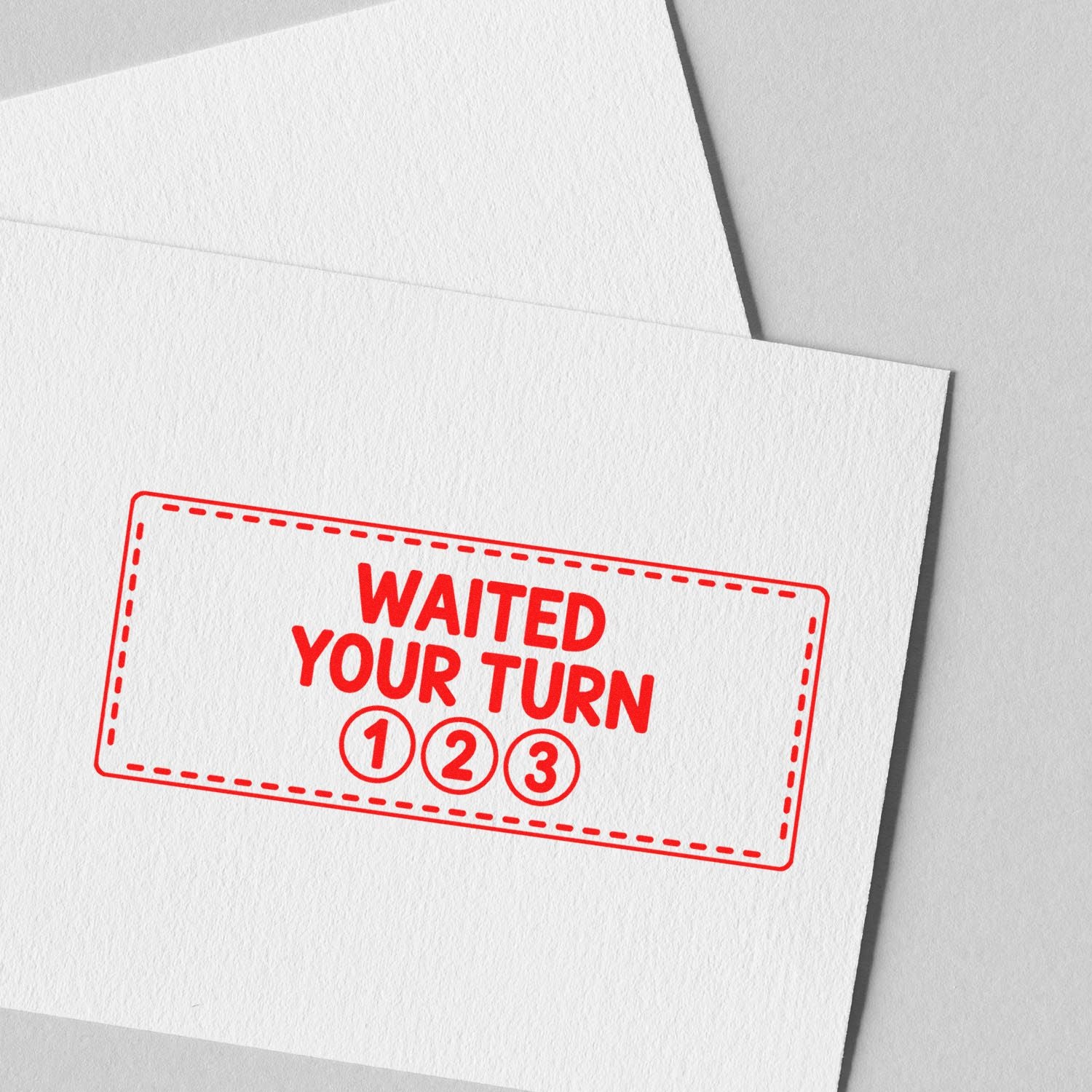 Red waited your turn stamp seal with 1-2-3 on white textured paper.
