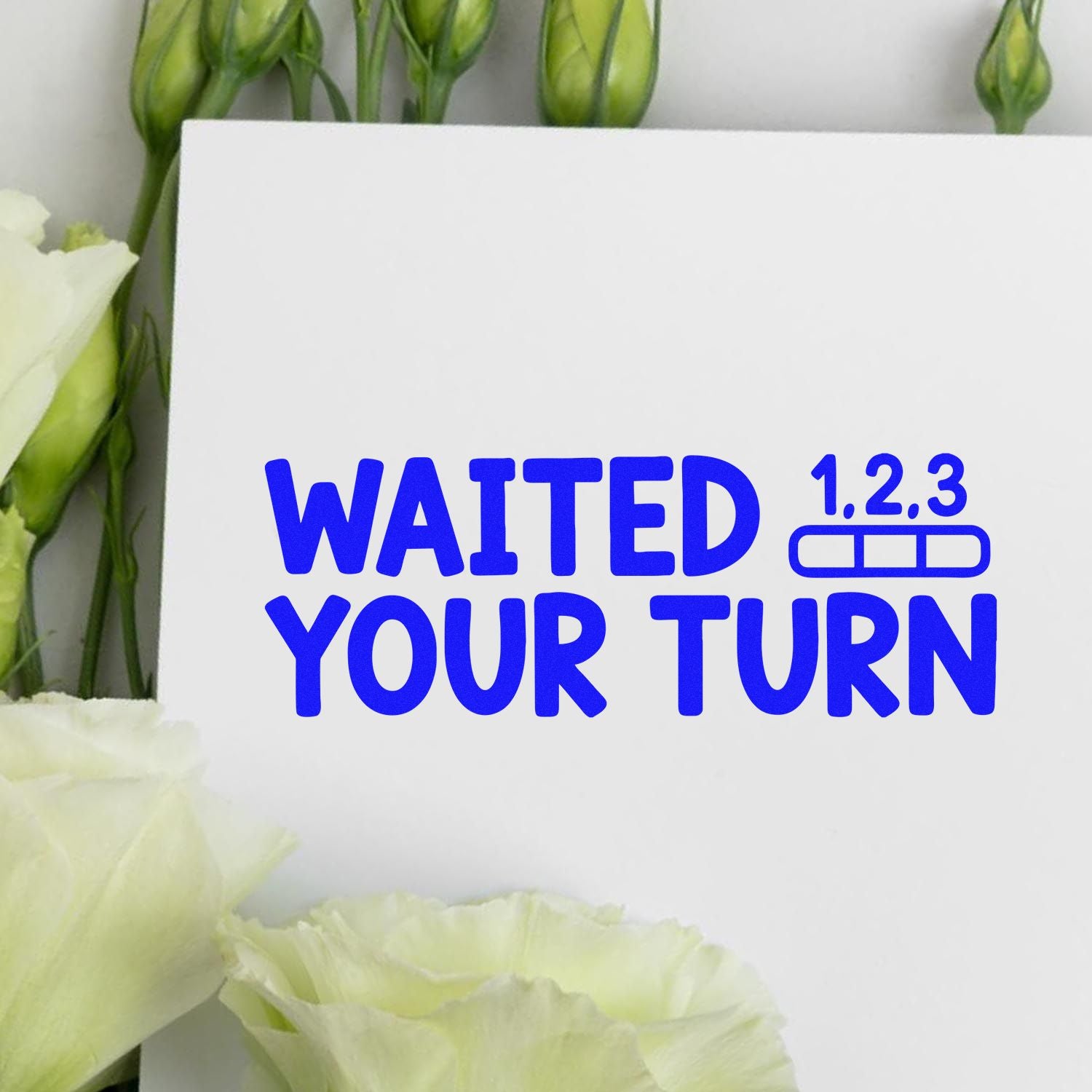 Blue WAITED YOUR TURN stamp and seal design with 1.2.3 icon on a white card, surrounded by green buds and white flowers.