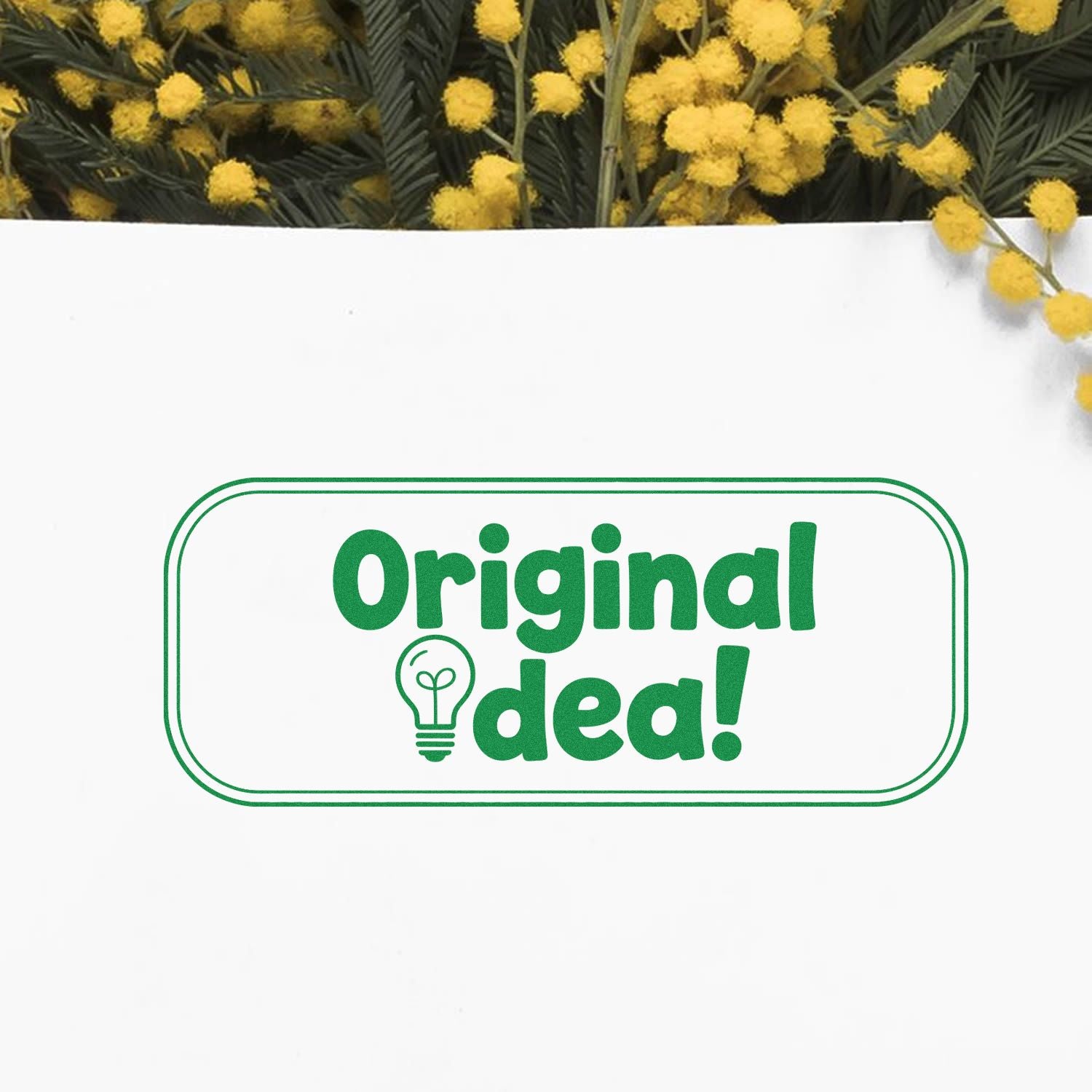 Green Original idea stamp seal with lightbulb icon on white, framed by yellow flowers.