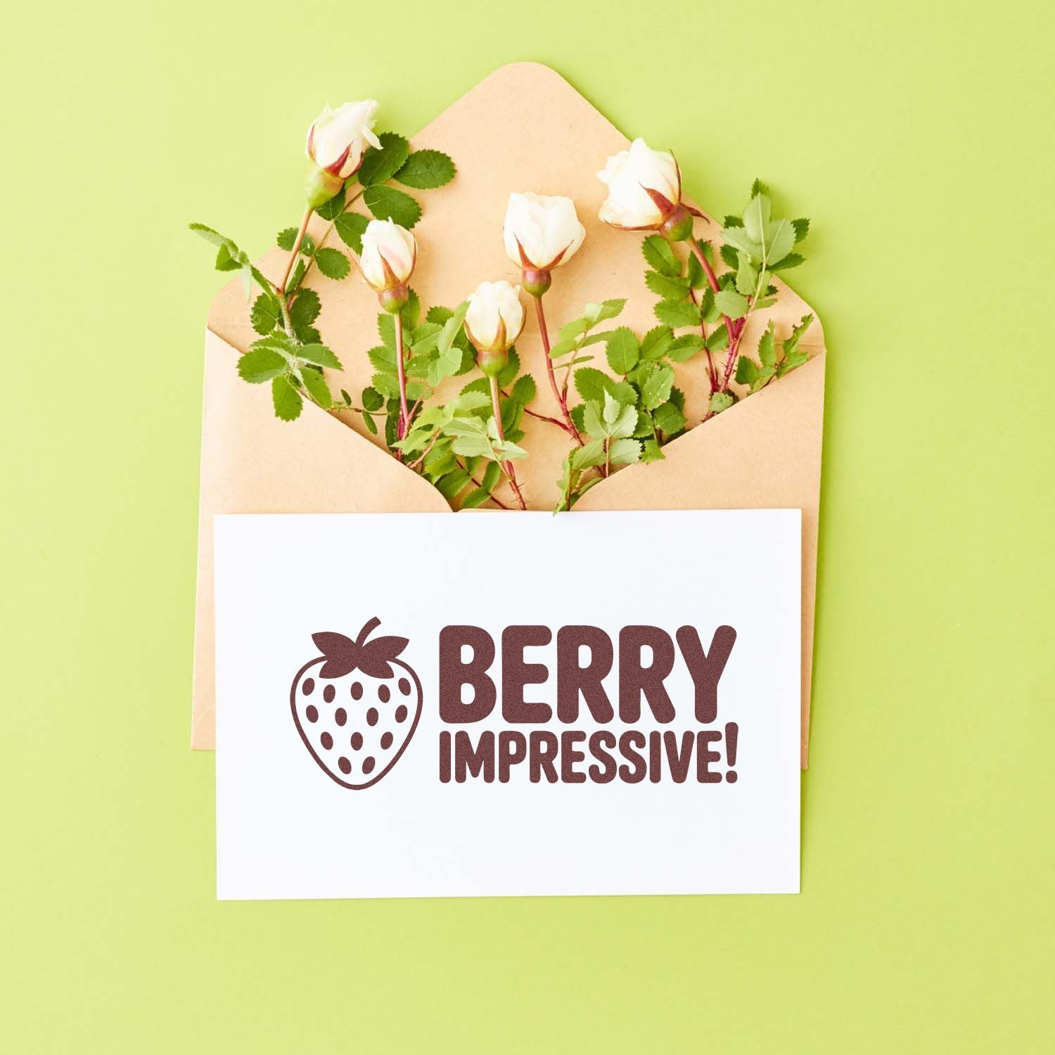 Berry Impressive strawberry stamp and seal on white card, with beige envelope, white rosebuds, and green leaves on light green background.