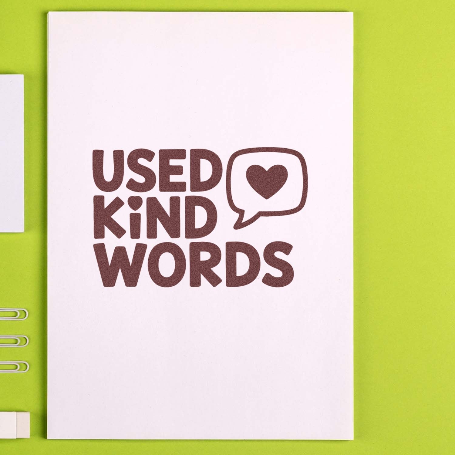 Brown Used Kind Words stamp and seal design on white card with heart speech bubble, on lime green background.