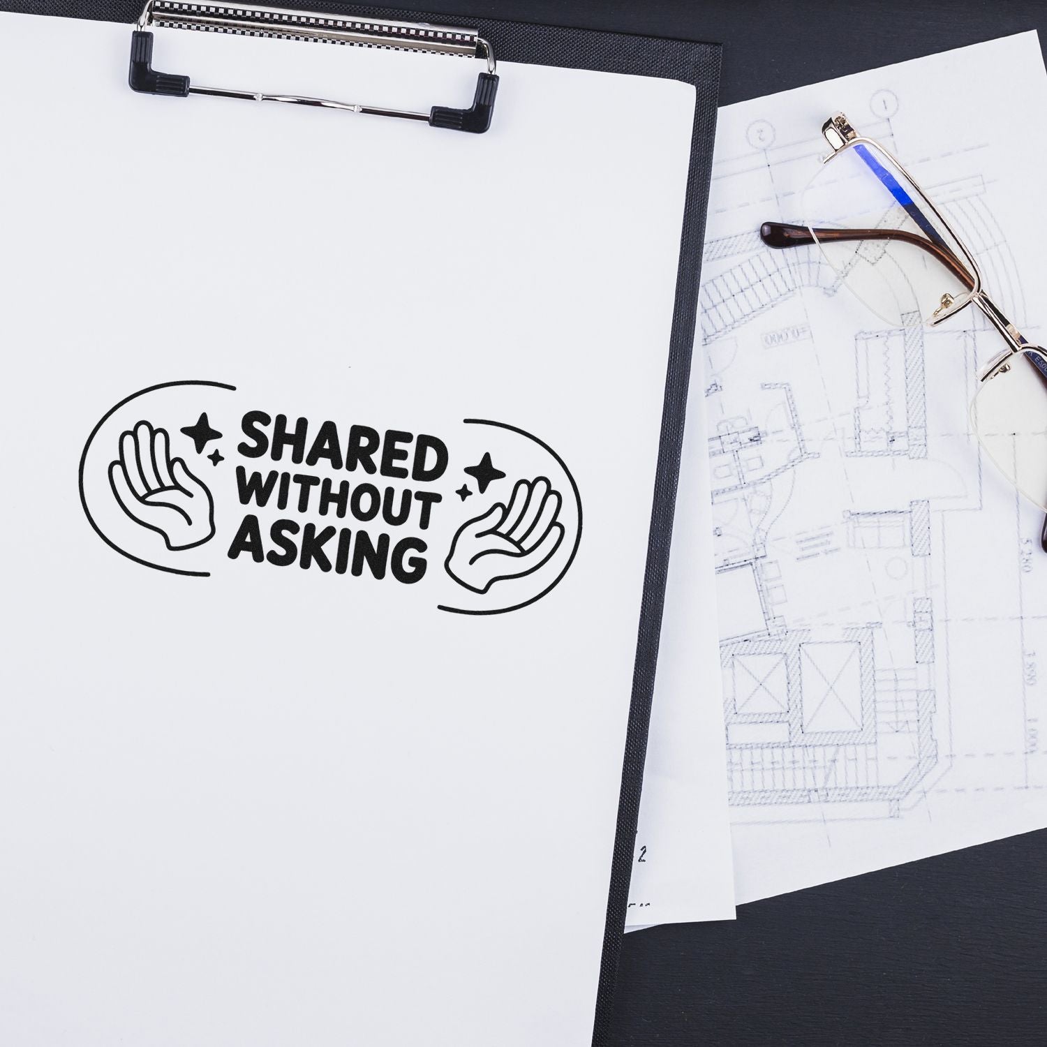 Black stamp and seal reading Shared Without Asking on a white clipboard beside eyeglasses and blueprint sketches.