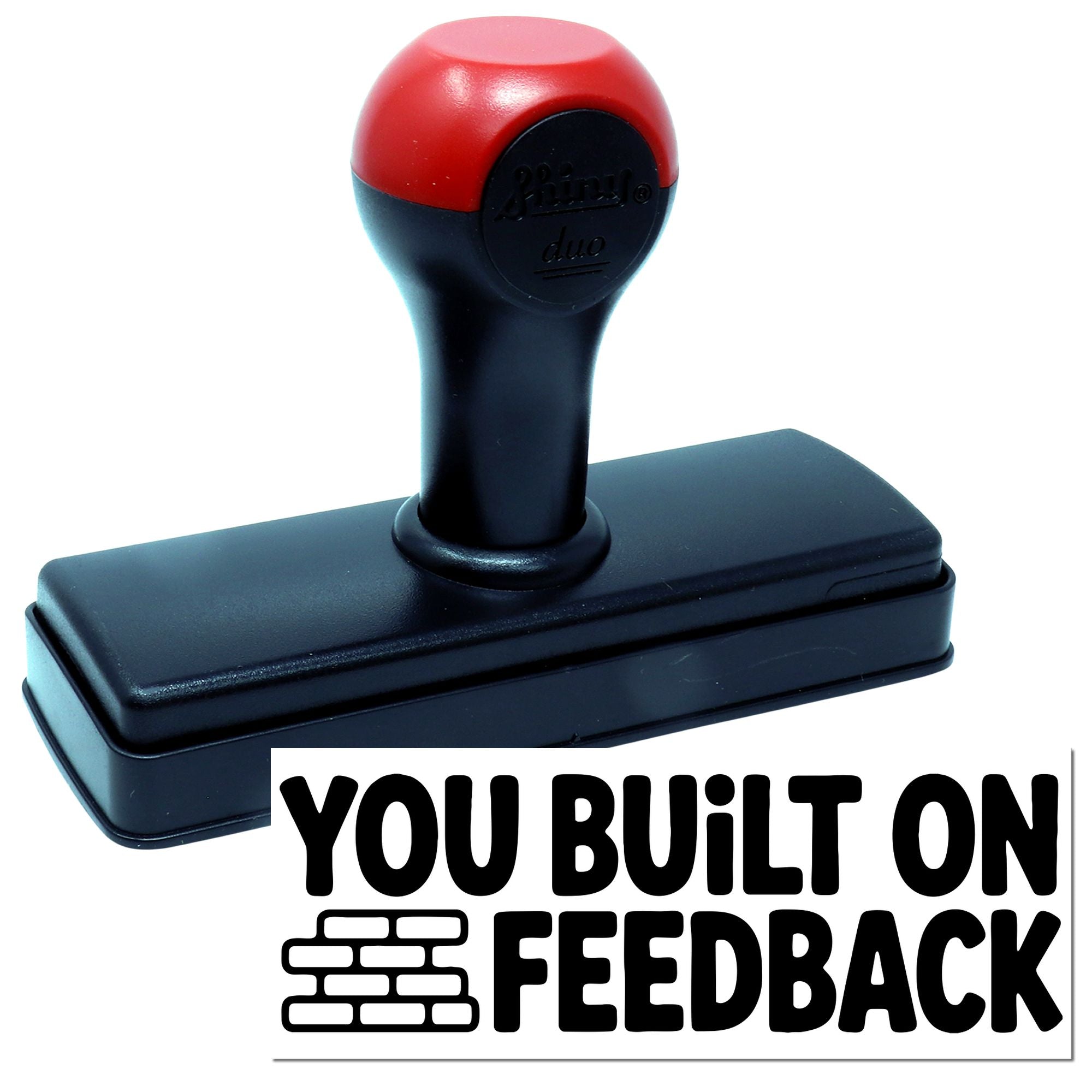 Red and black self-inking stamp and seal with YOU BUILT ON FEEDBACK text and brick icon