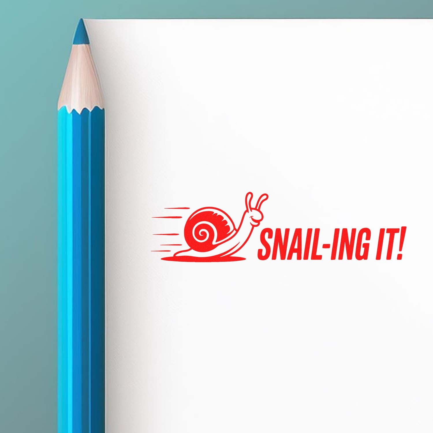 Red snail stamp and seal reading SNAIL-ING IT! beside a blue pencil on white paper.