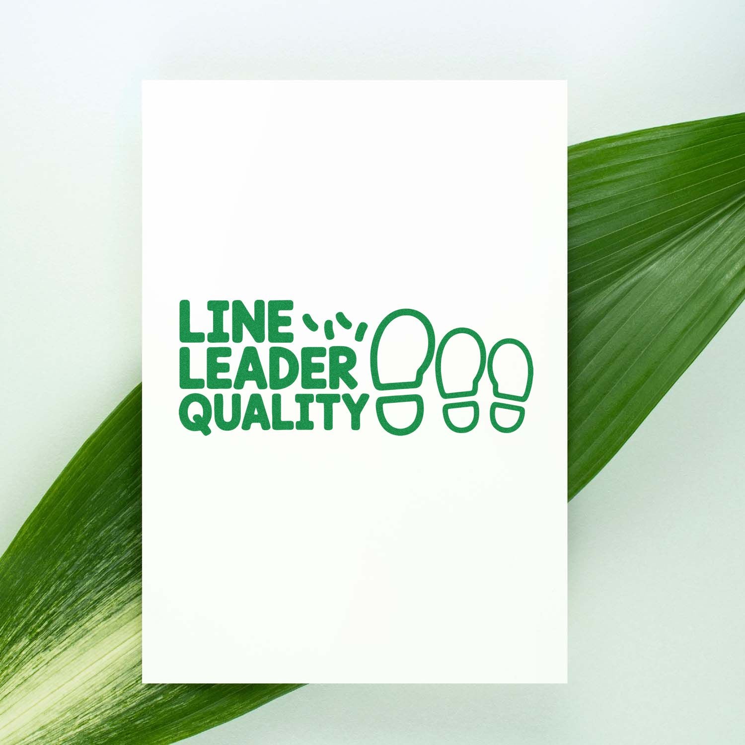 Green Line Leader Quality stamp seal on a white card, with footprint icons over a soft green leaf background.