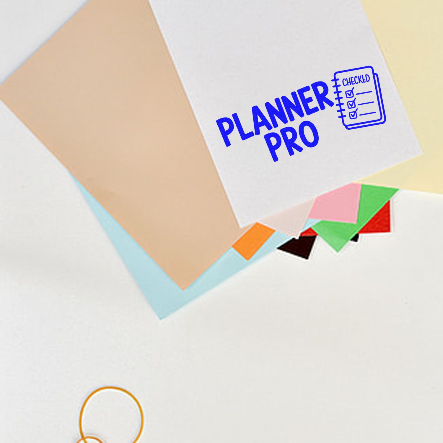 Blue PLANNER PRO stamp and seal set on white paper, with checklist icon and pastel sticky-note tabs.