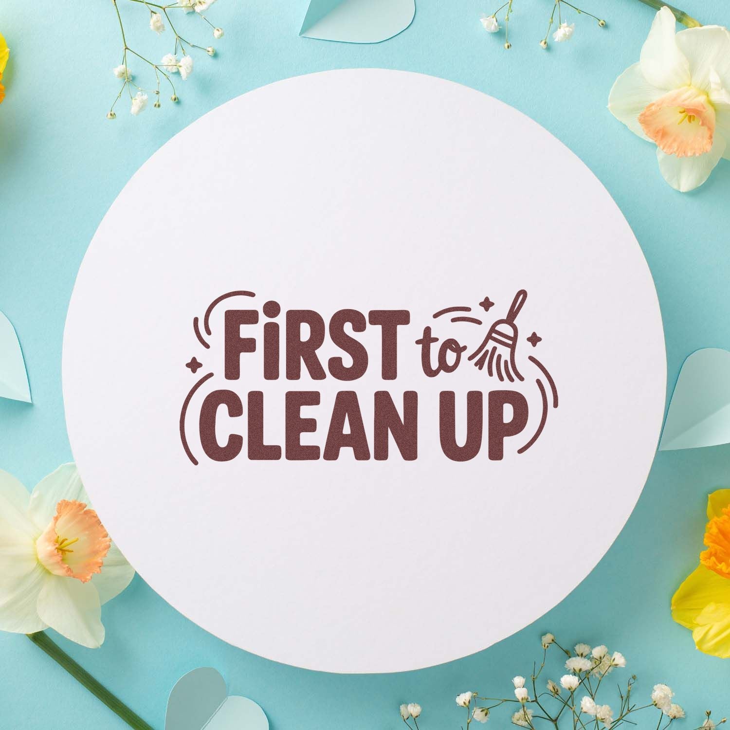 Brown First to Clean Up stamp seal on a white circle, set on a pastel aqua background with soft flowers.