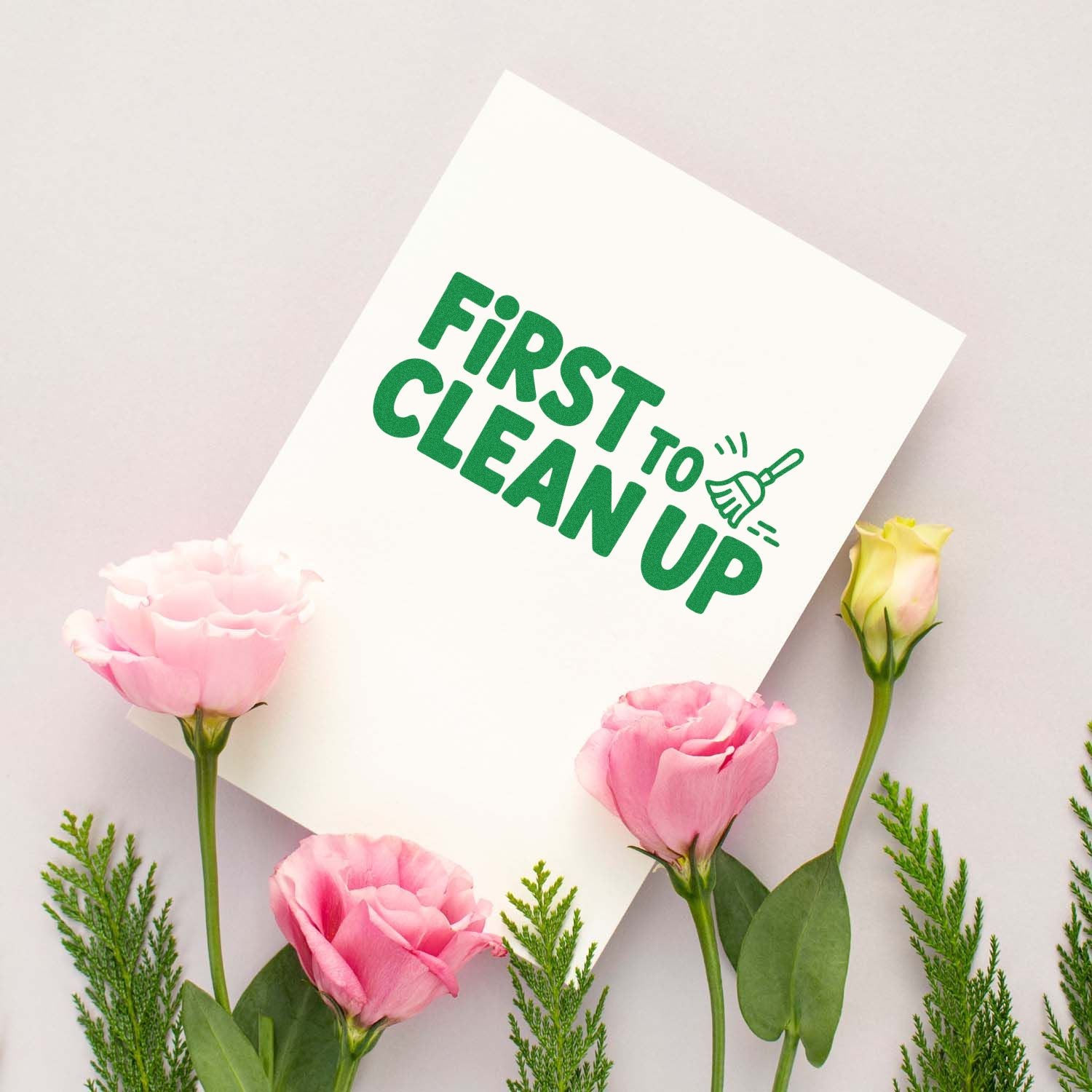 Green FIRST TO CLEAN UP stamp and seal on white card, framed by pink flowers and greenery.