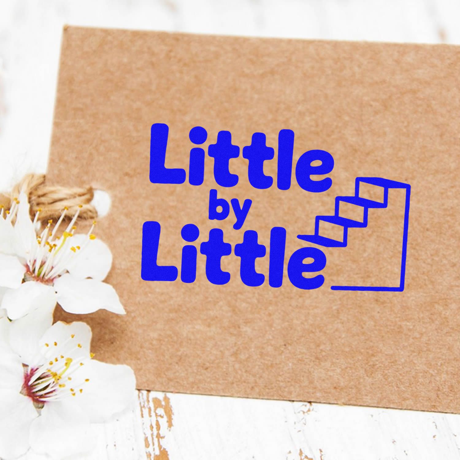 Blue Little by Little stamp and seal logo on kraft paper, with stair icon and white blossoms