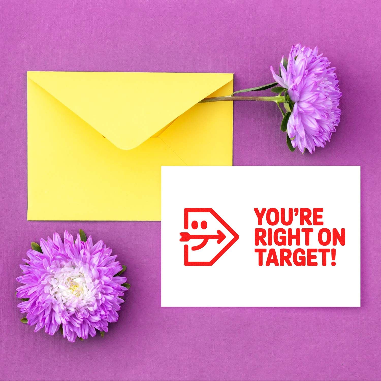 Yellow envelope with purple flowers and a white card featuring a red stamp and seal: YOURE RIGHT ON TARGET!