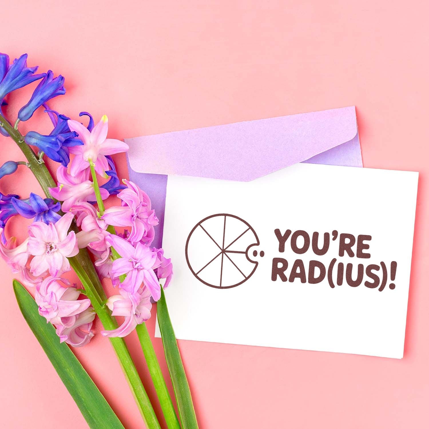 Lavender stamp seal card with YOURE RADIUS! text, purple envelope, and pink and blue hyacinth flowers on a pink background.