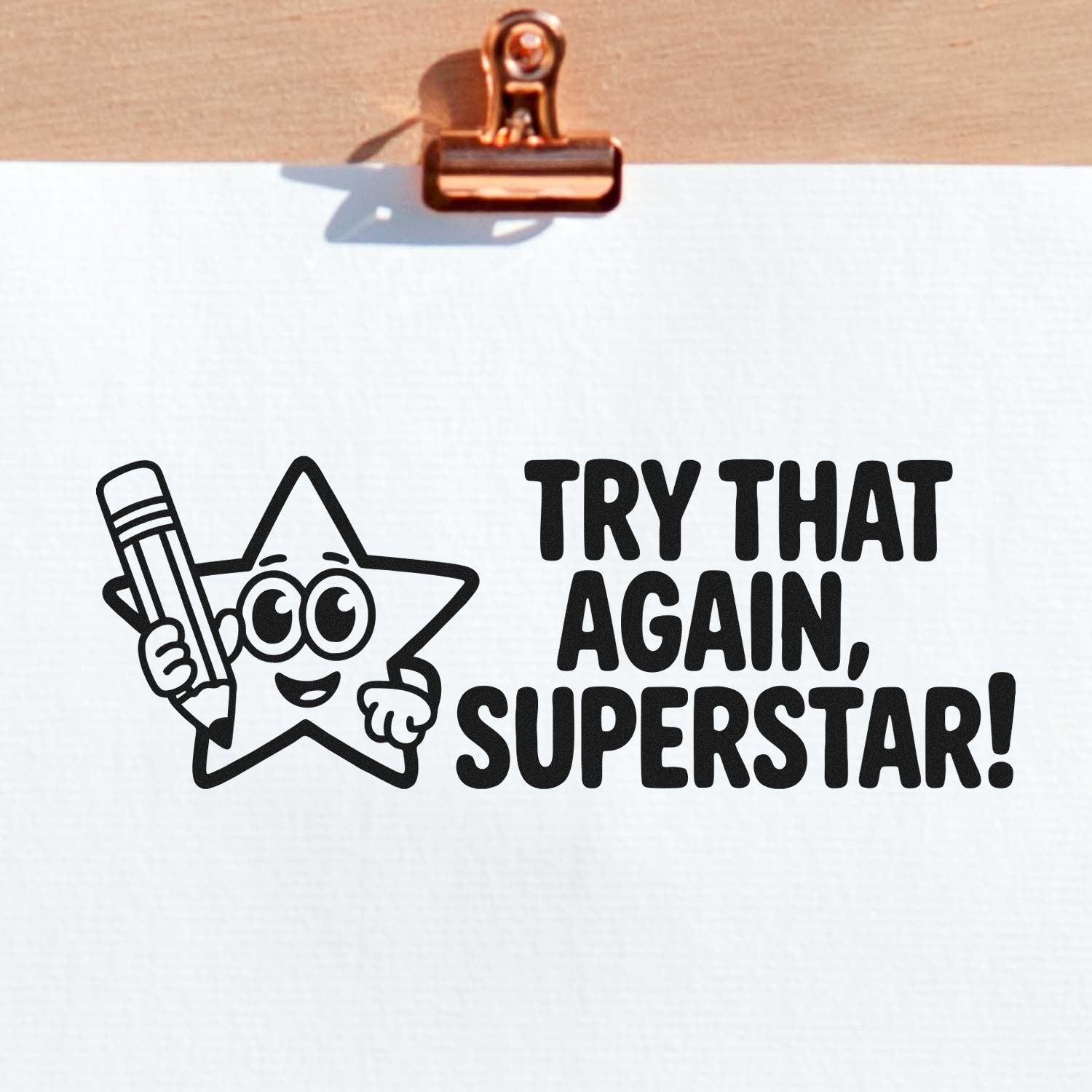 Black stamp and seal design on white paper with star mascot holding a pencil and bold Try That Again, Superstar!