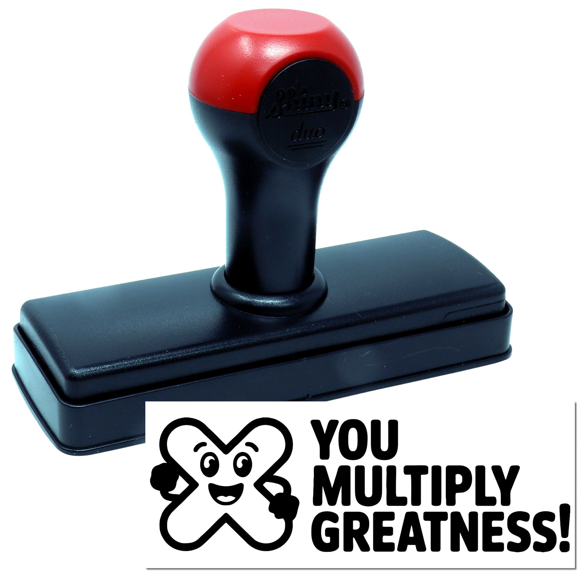 Black self-inking stamp with red handle and a You Multiply Greatness! seal impression in black.