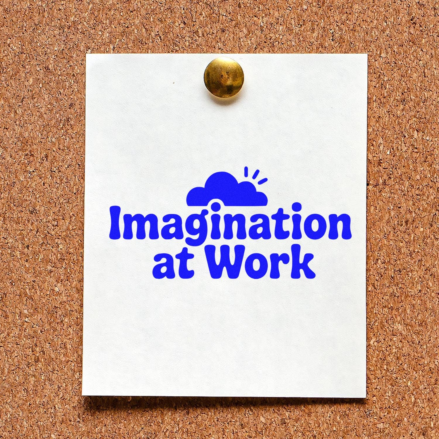 Blue Imagination at Work rubber stamp seal on white paper, pinned to a cork board with a brass tack.