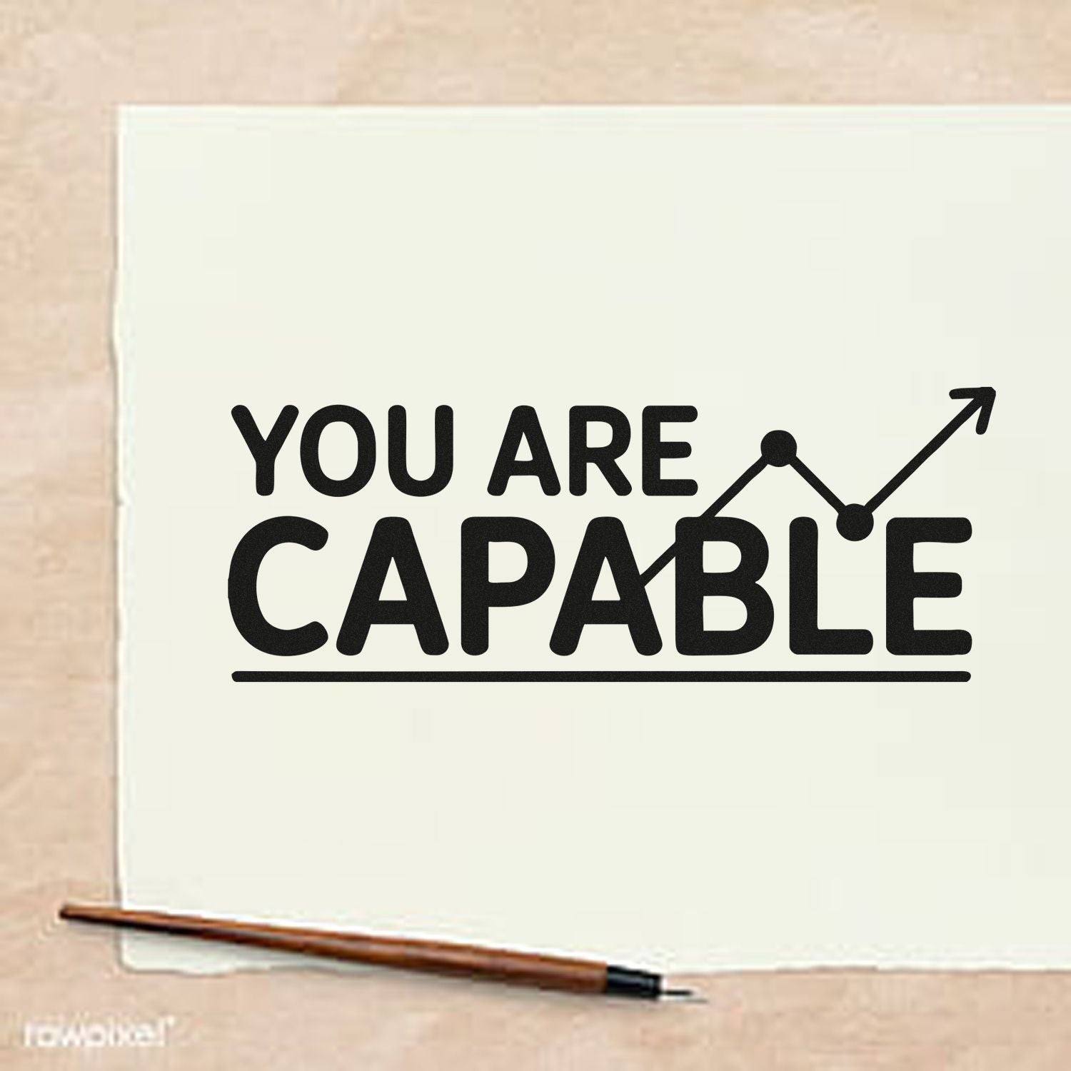 Black YOU ARE CAPABLE custom stamp on white paper, with upward arrow graphic, beige background, and brown seal handle.
