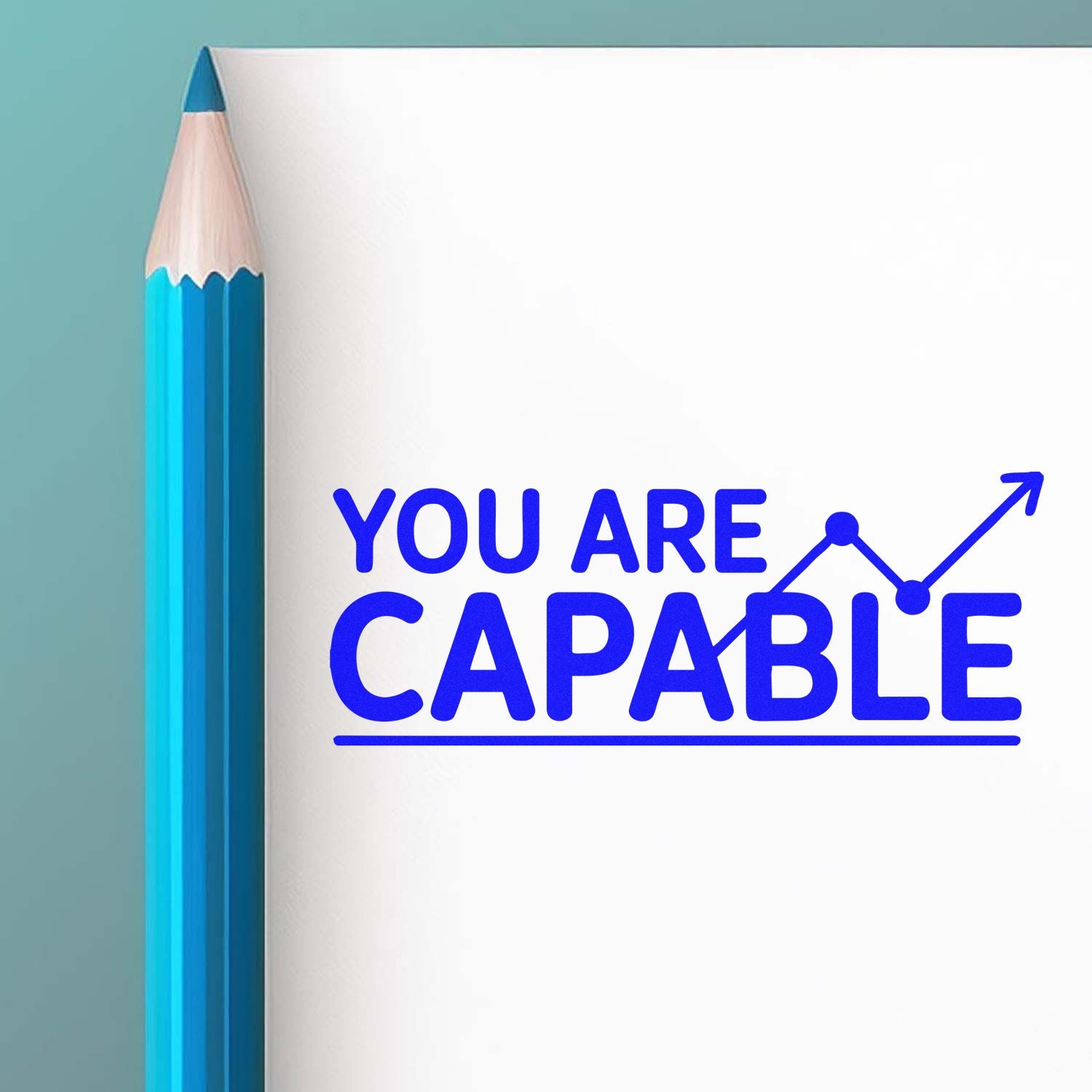 Blue motivational stamp seal reading YOU ARE CAPABLE beside a turquoise pencil on white paper, with an upward growth arrow.