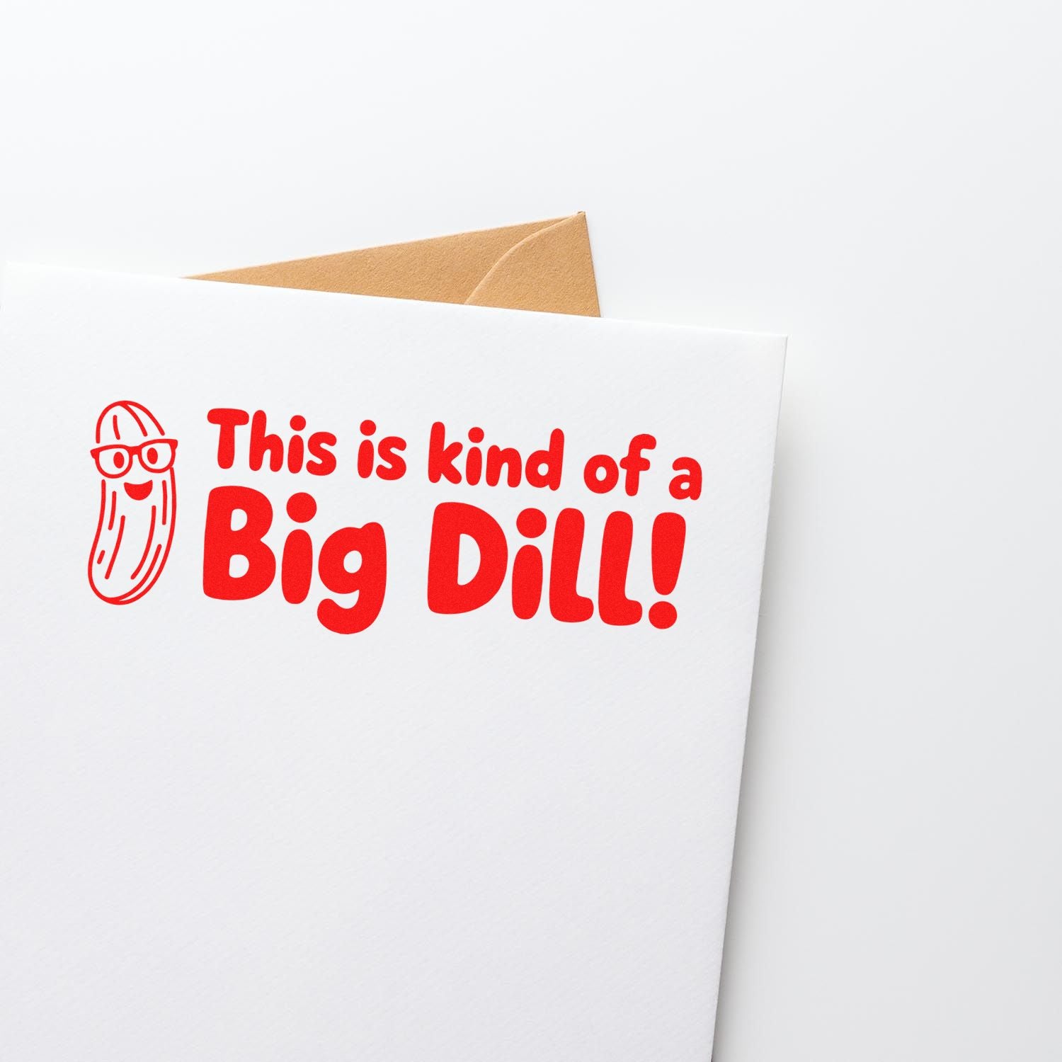Red custom stamp and seal on white card with tan envelope, reading This is kind of a Big Dill! and a cartoon pickle.
