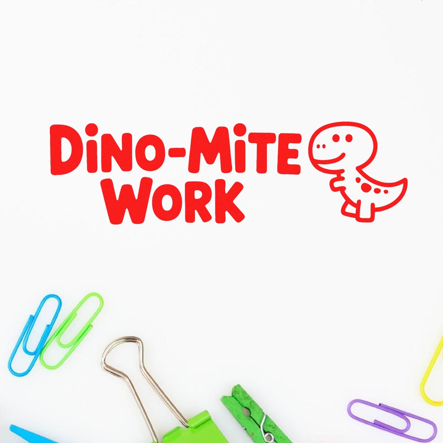 Red Dino-Mite Work stamp and seal with dinosaur outline on white, surrounded by colorful paper clips and binder clips.