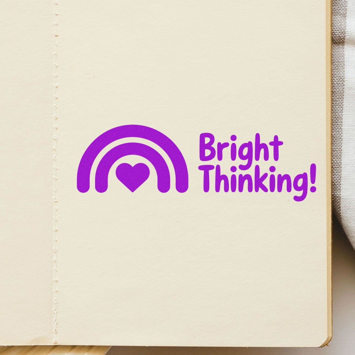 Purple Bright Thinking stamp and seal with rainbow and heart on cream paper page.