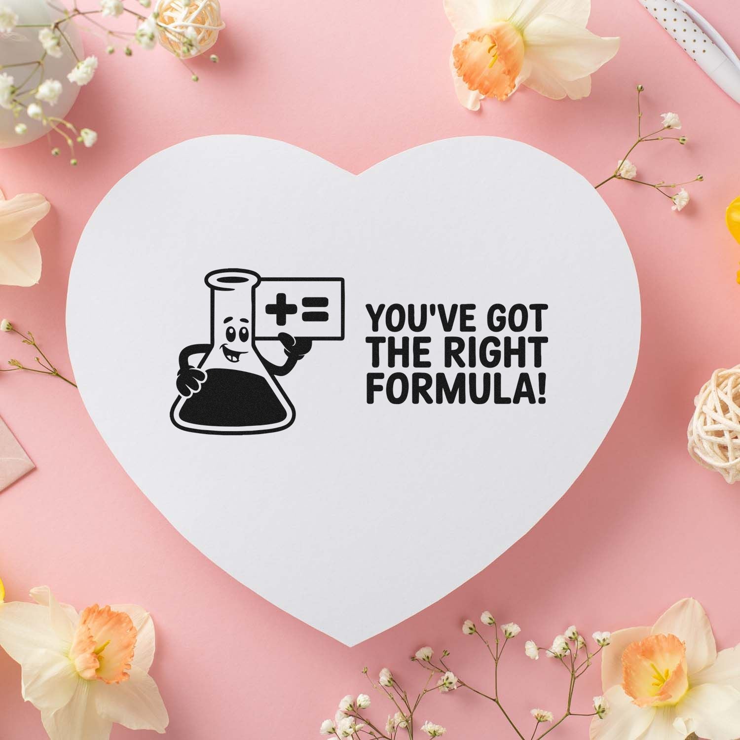 White heart-shaped stamp seal on pink background with black chemistry flask and bold text, Youve got the right formula!