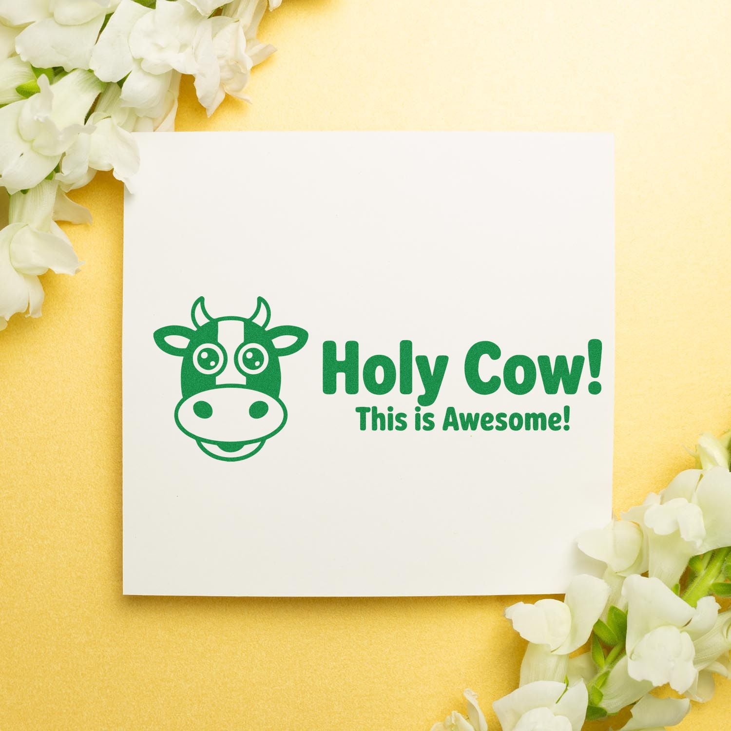 Green cow stamp and seal design with Holy Cow! This is Awesome! on white card, yellow background, white flowers.