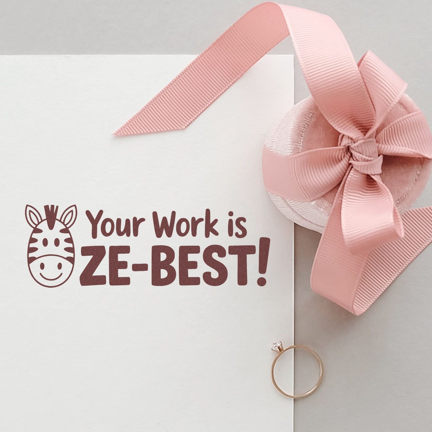 Pink stamp and ribbon seal with zebra icon and Your Work is ZE-BEST! on a white card.