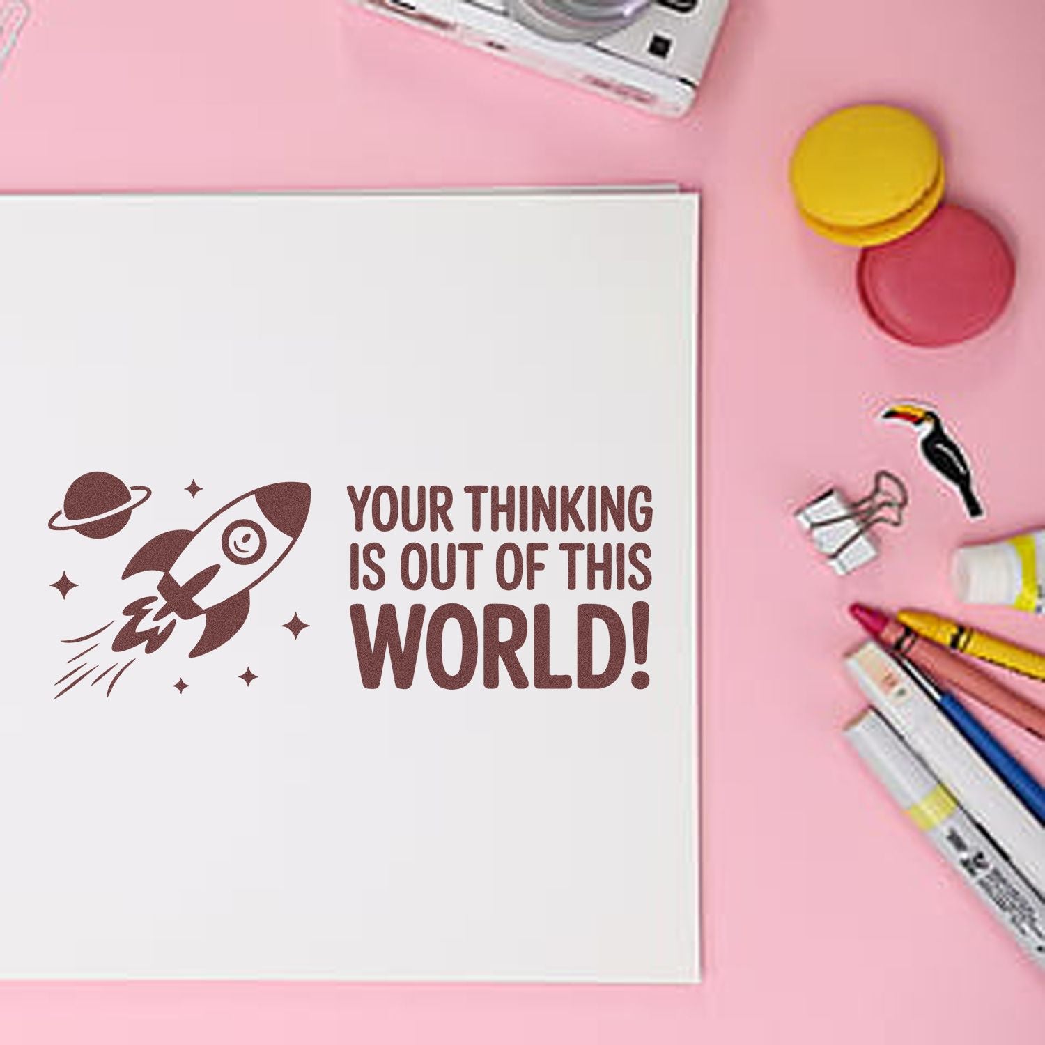 Brown rocket stamp and Your thinking is out of this world! on white card, with pink background and colorful seal tools.